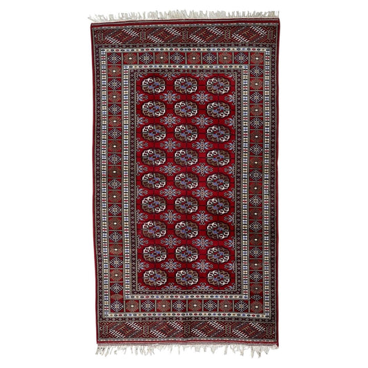 Vintage Uzbek Bukhara wool rug from the 1960s with crimson red field and repetitive octagonal gul motifs, 4 x 7 feet