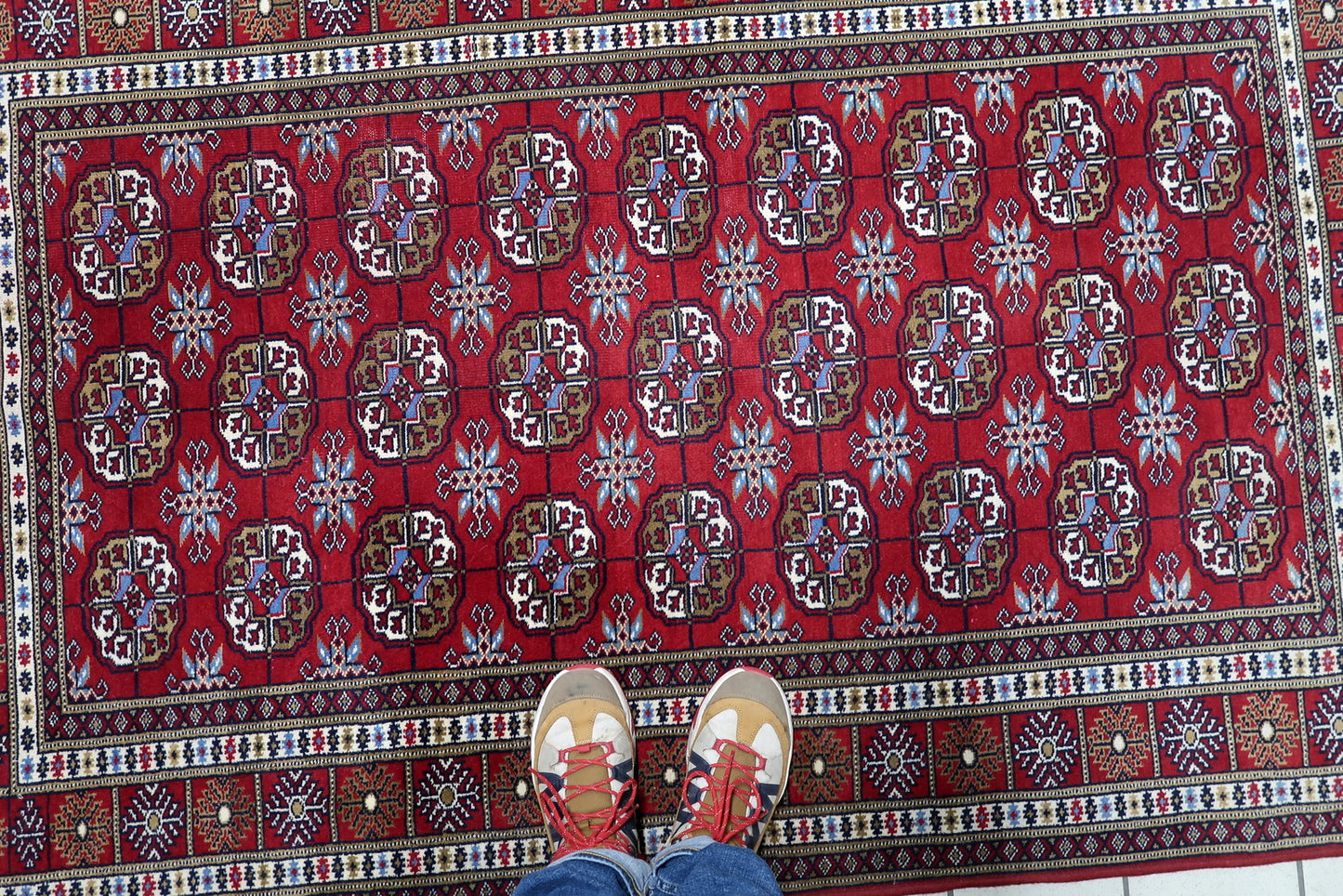Uzbek tribal rug with expansive field of octagonal guls and rich, lustrous crimson background