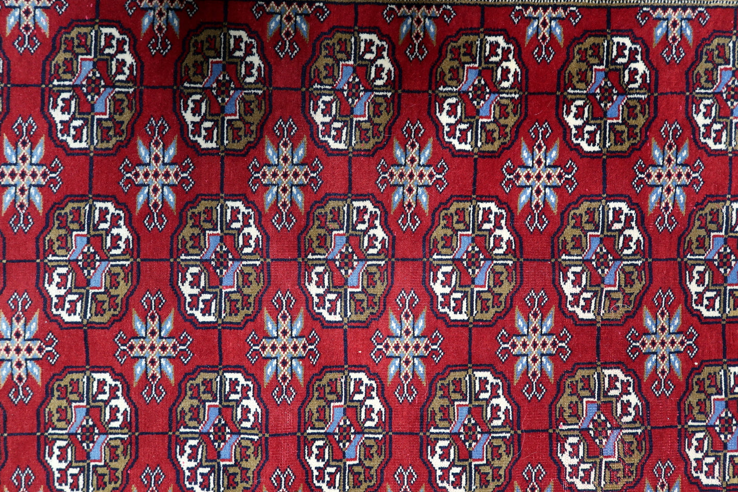 View of traditional flat-woven kilim end and fringe at the top of a vintage Bukhara tribal floor covering