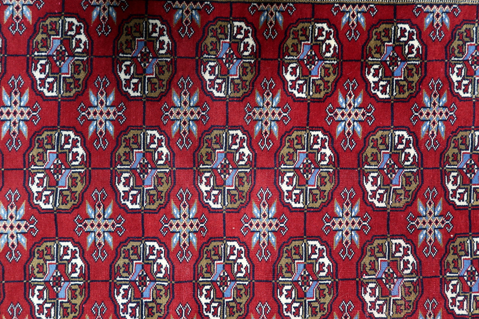 View of traditional flat-woven kilim end and fringe at the top of a vintage Bukhara tribal floor covering