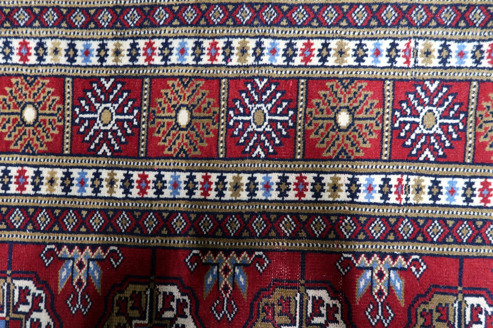 Crimson red, ivory, navy blue and copper vintage Uzbek rug with repetitive octagonal medallions and geometric precision