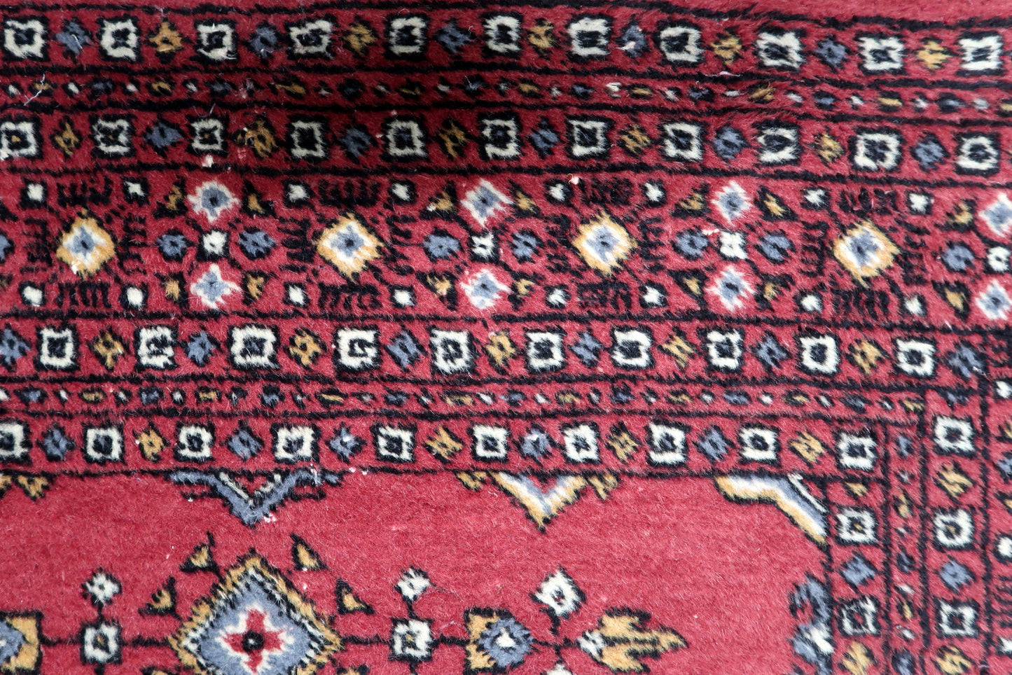Hand-knotted wool rug in good vintage condition featuring traditional geometric patterns and clear motif details