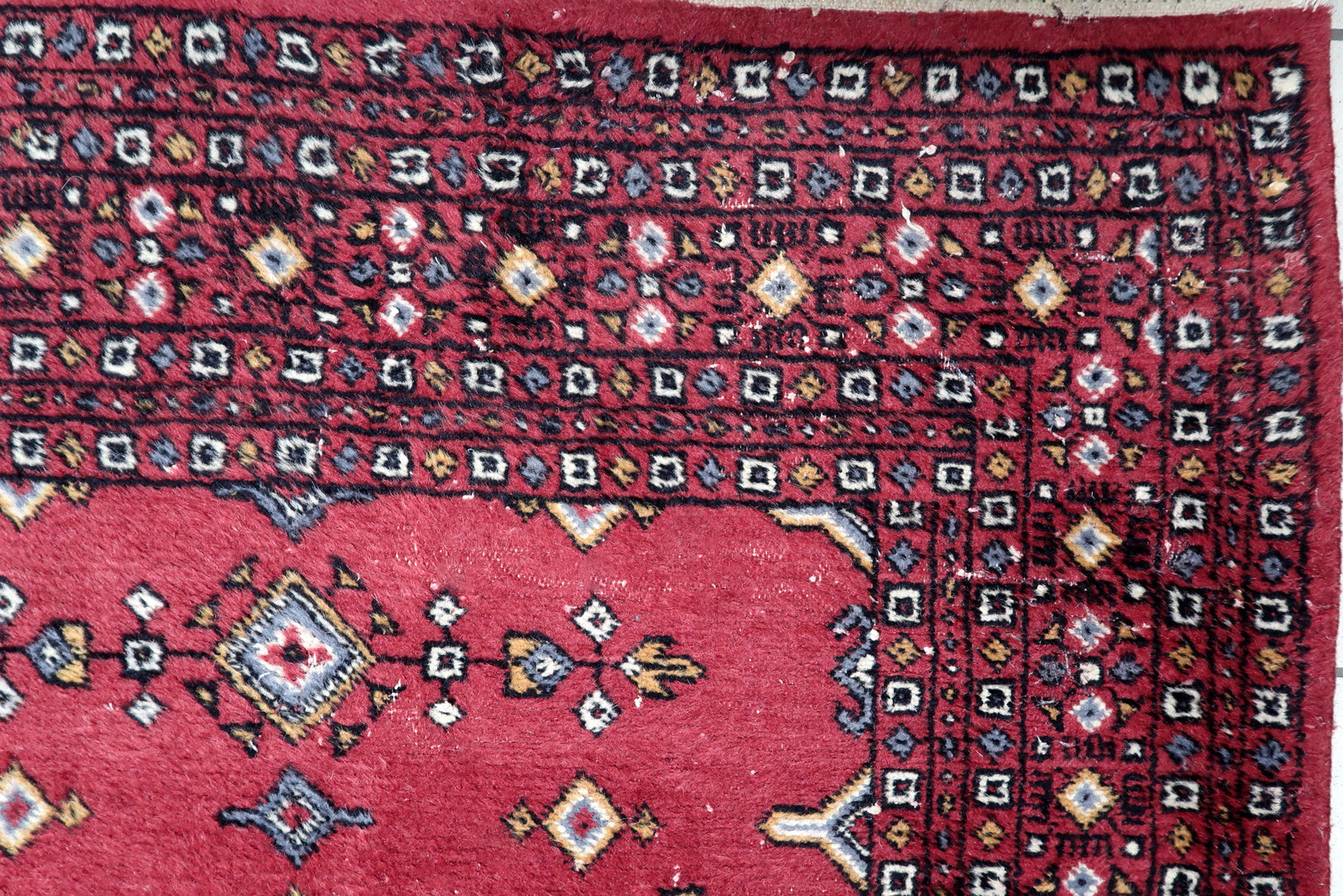 Close-up of geometric precision showing deep blue, ivory and golden accents on traditional Bukhara diamond patterns