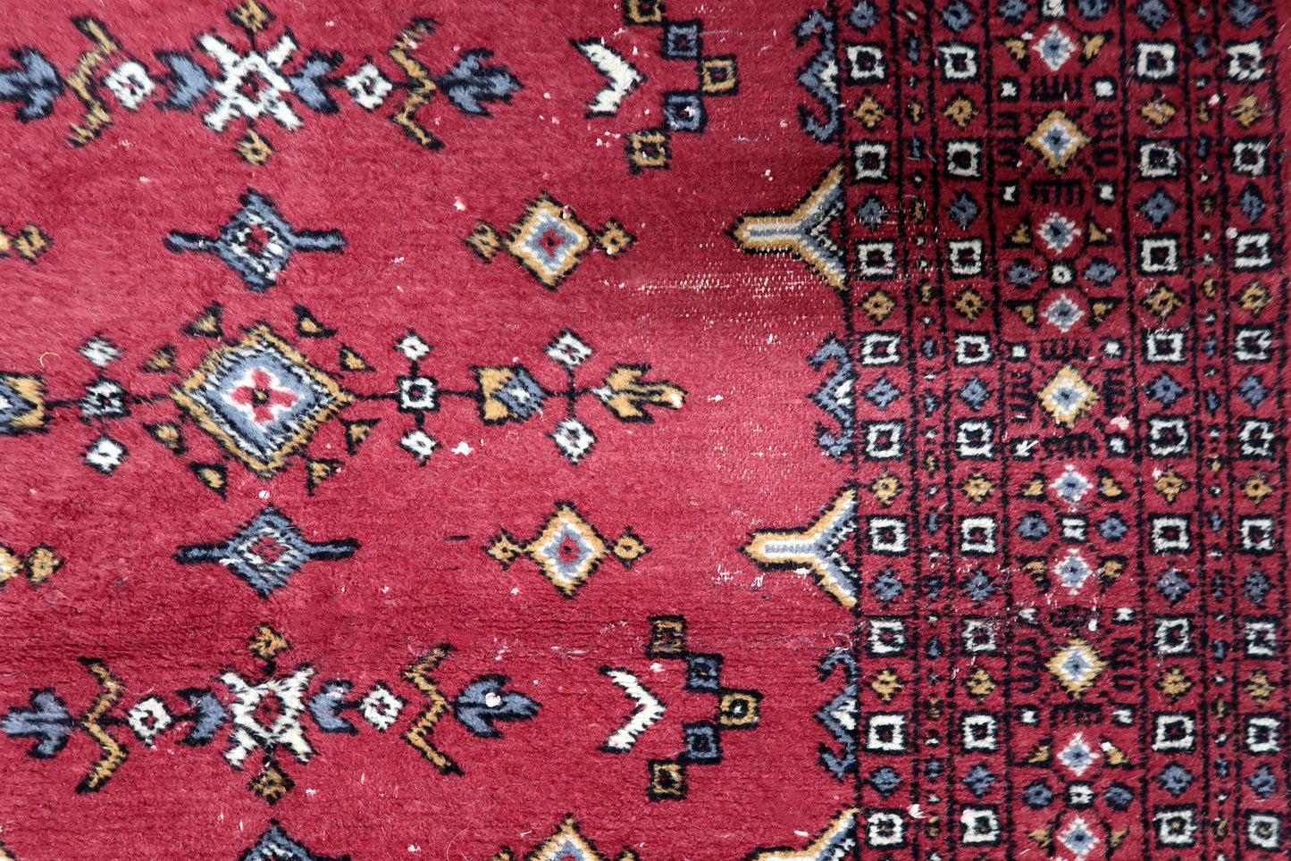 Soft durable wool pile texture of a hand-knotted 1950s Bukhara rug with some areas of low pile from age