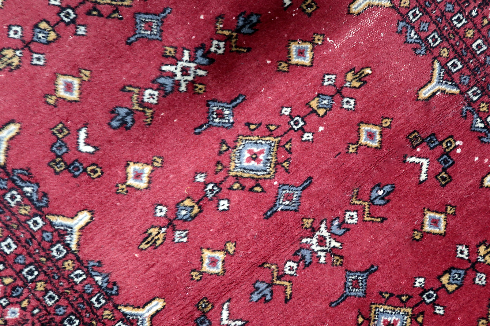 View of original white fringes preserved on both ends of a vintage Uzbek tribal floor covering