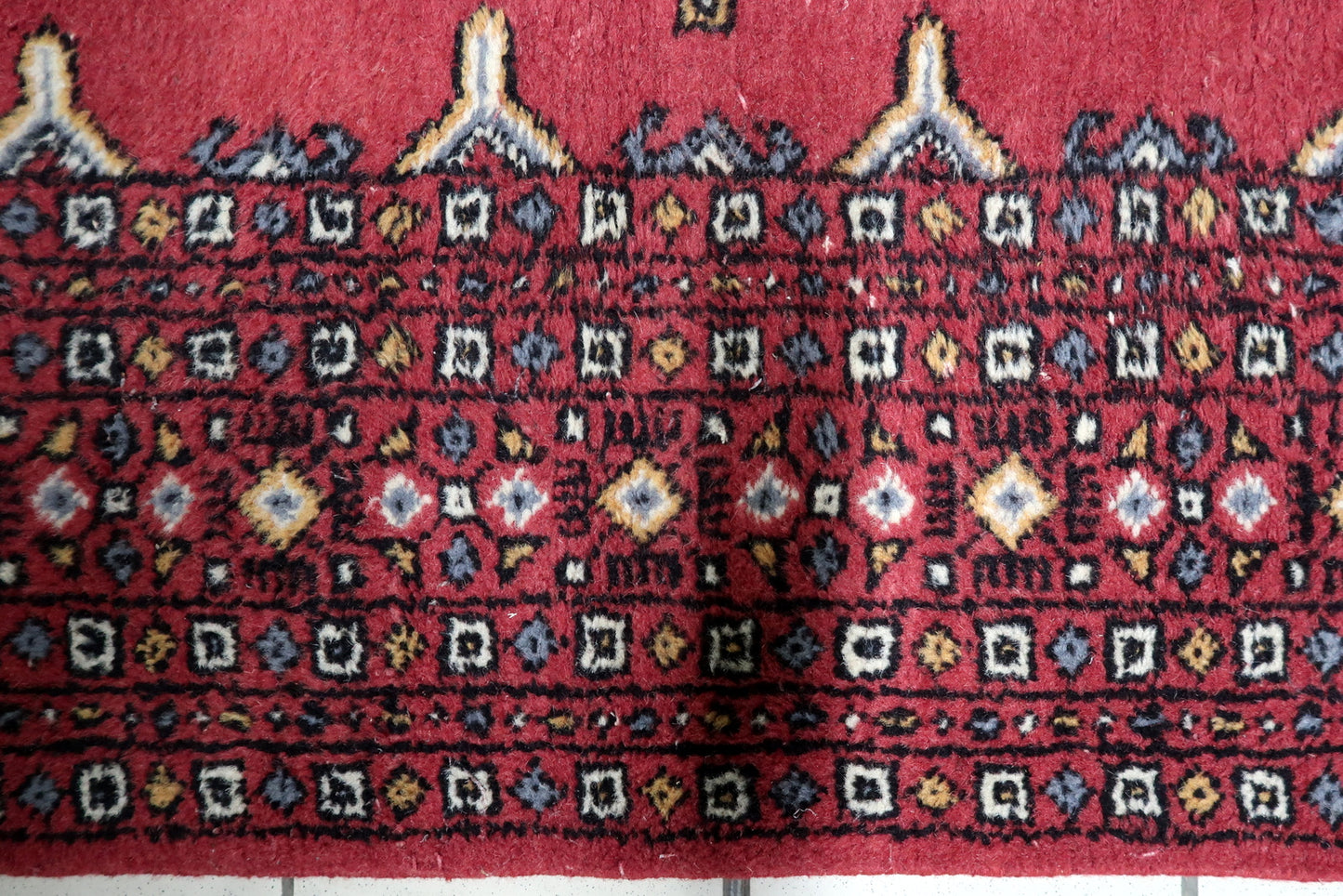Vintage 1950s Central Asian Bukhara carpet with harmonious color palette and warm visual depth