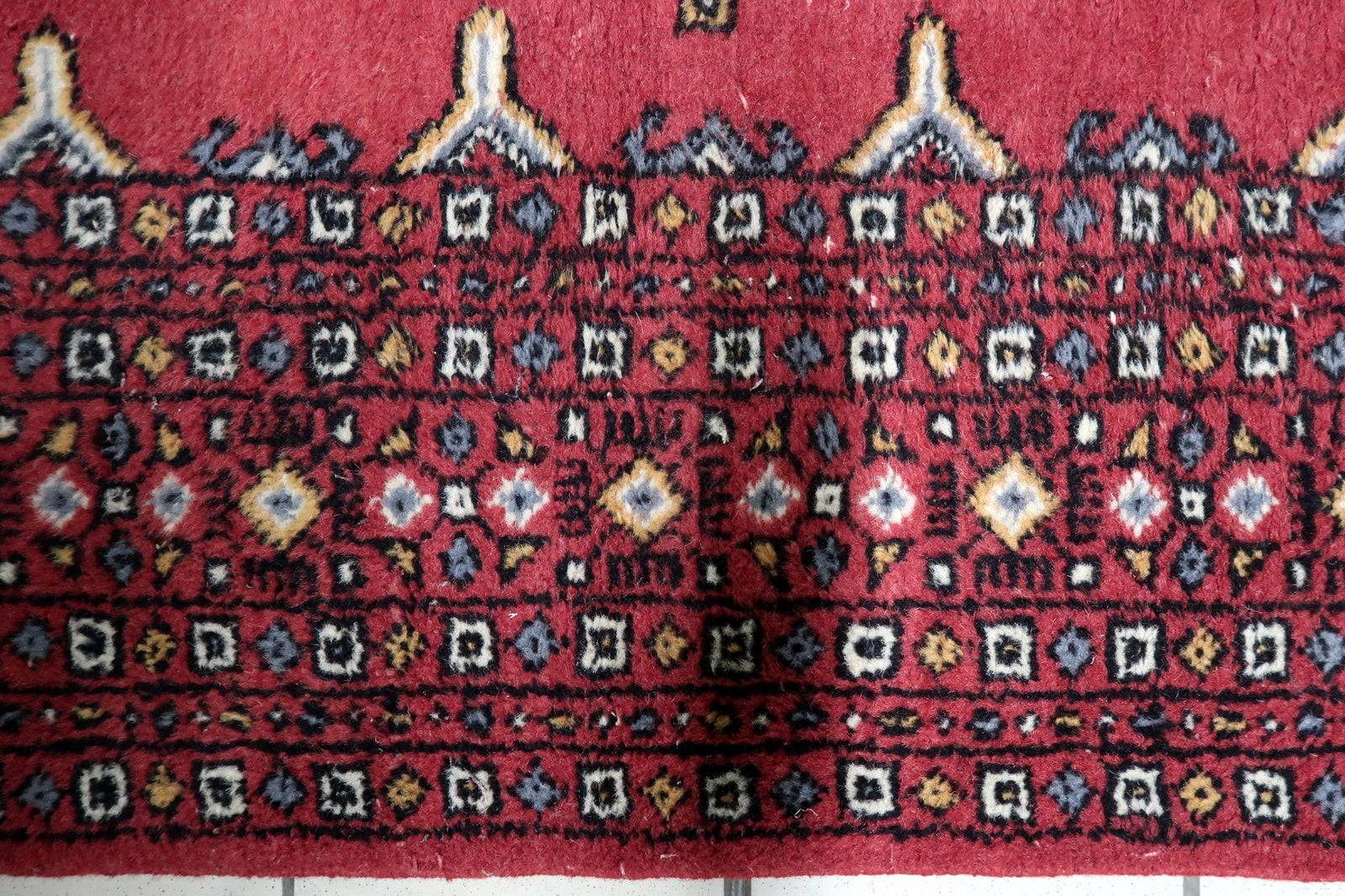 Vintage 1950s Central Asian Bukhara carpet with harmonious color palette and warm visual depth