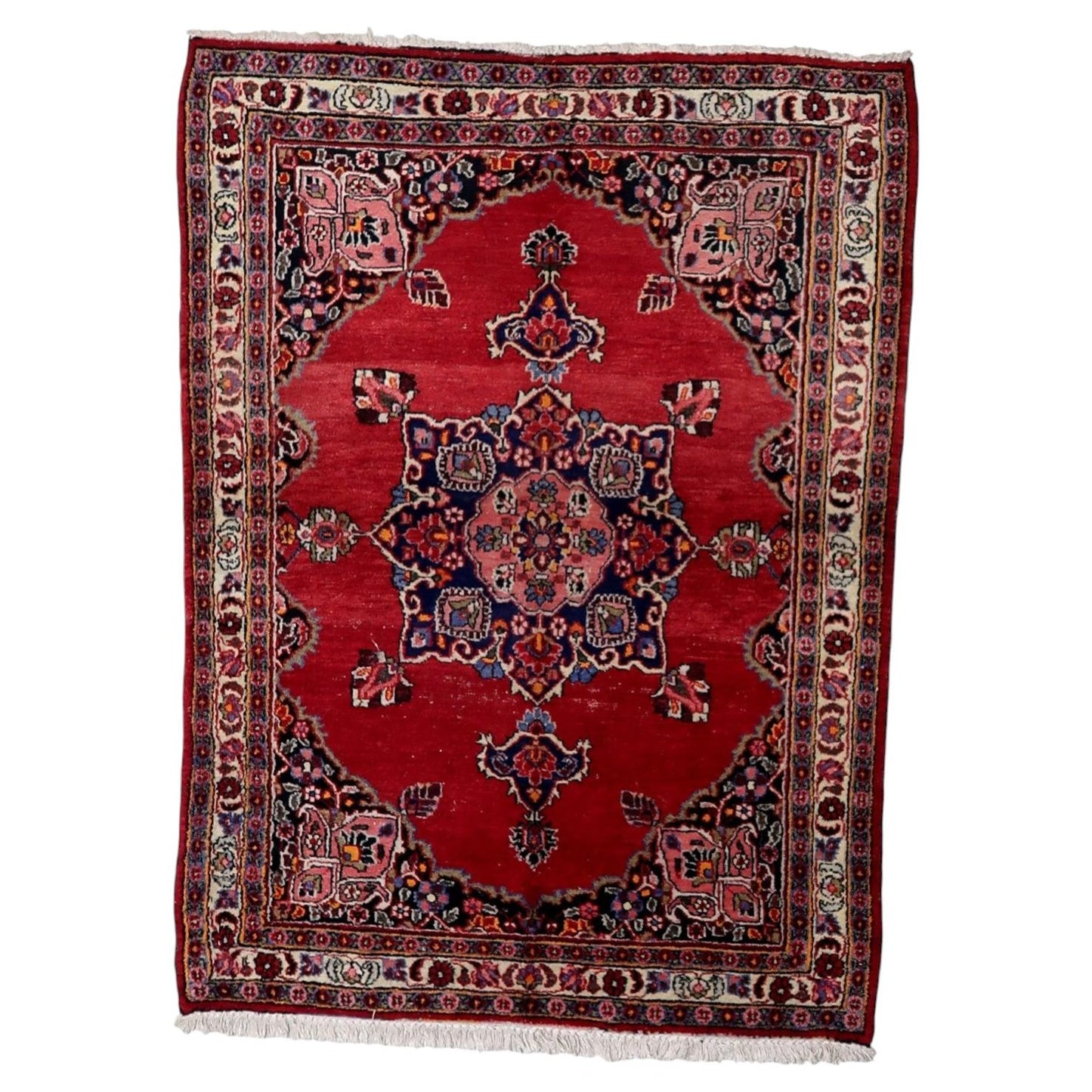 Antique 1920s Persian Kazvin wool rug with warm red field and symmetrical central medallion in navy pink ivory and green, 4.4 x 5.9 feet