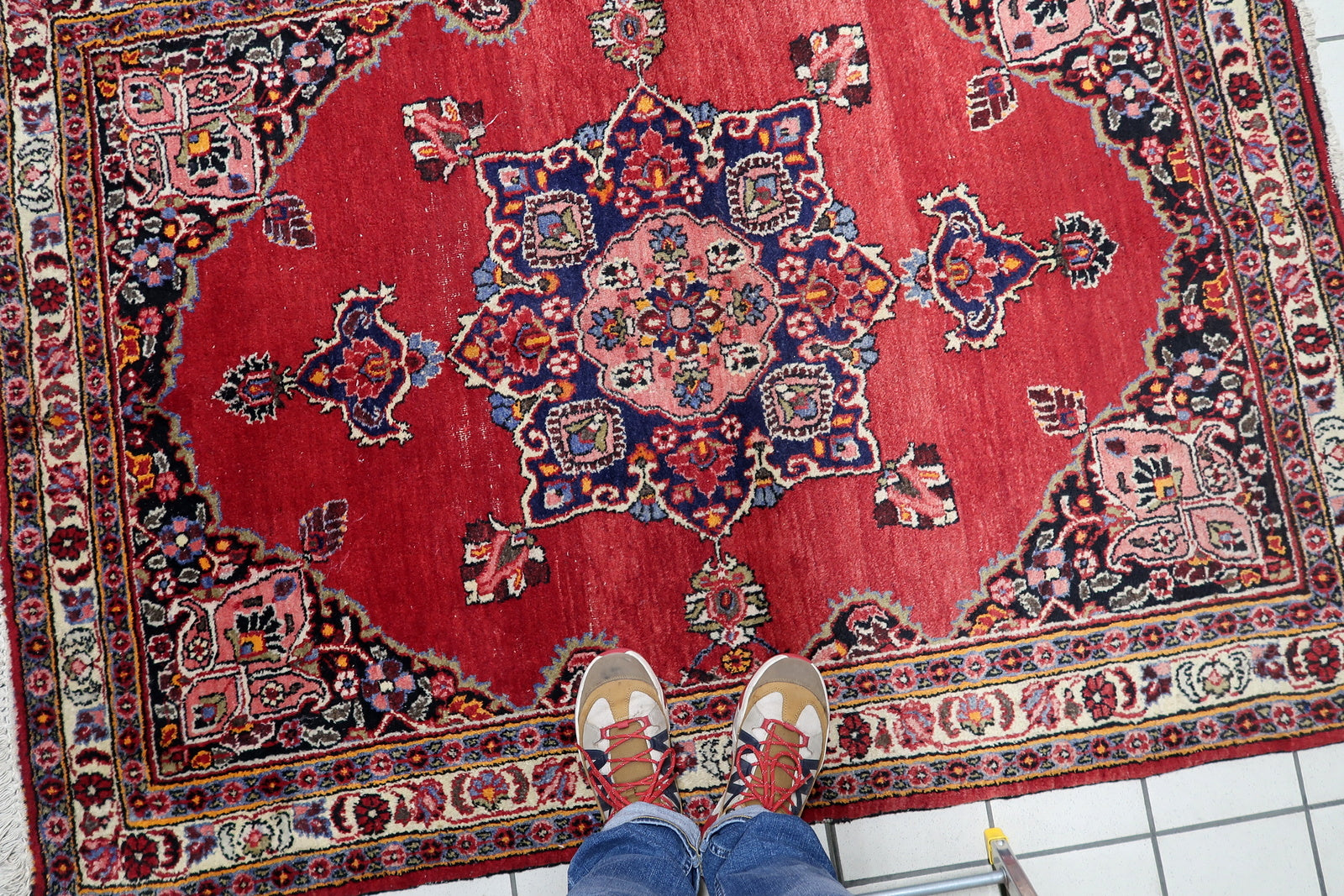 Persian Kazvin rug with rich red field adorned with detailed floral motifs and some areas of low pile from age
