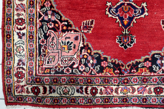Close-up of intricate botanical and curvilinear motifs in navy, pink and green on a hand-knotted Persian Kazvin carpet