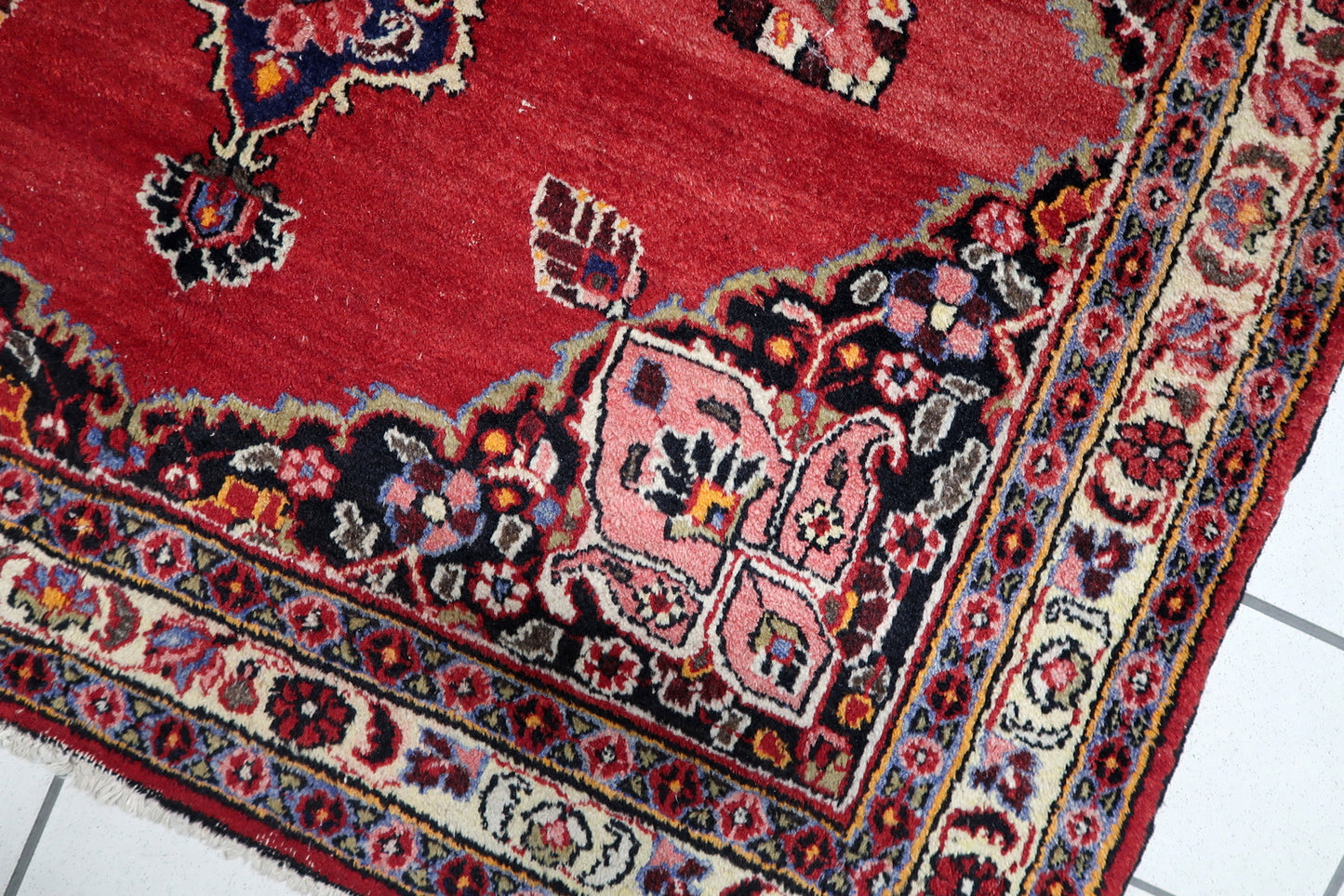 Full view of an antique Persian rug featuring balanced floral geometry and finely detailed multiple borders