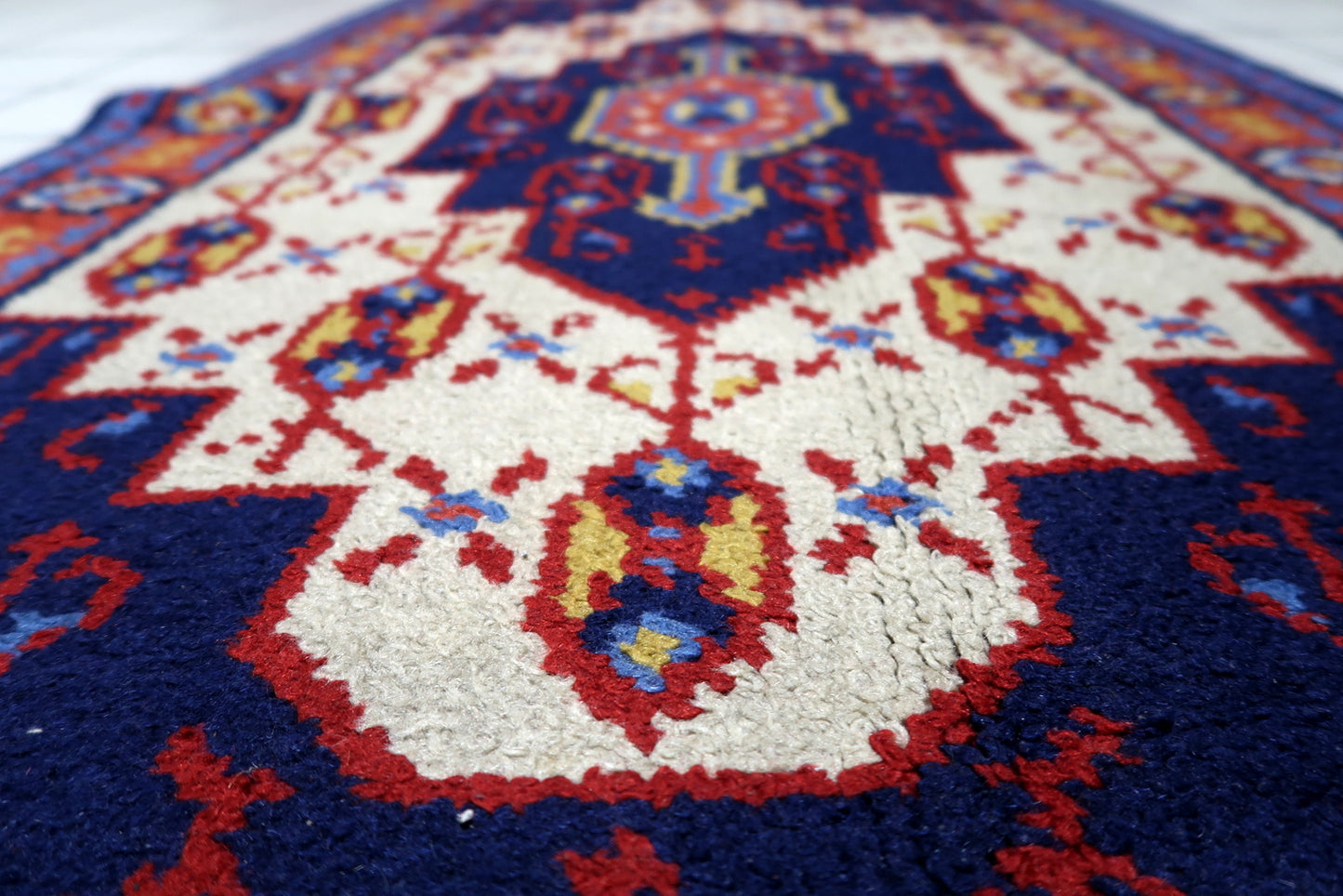 Soft wool pile texture of a 1950s French rug with lively colors and only light signs of age