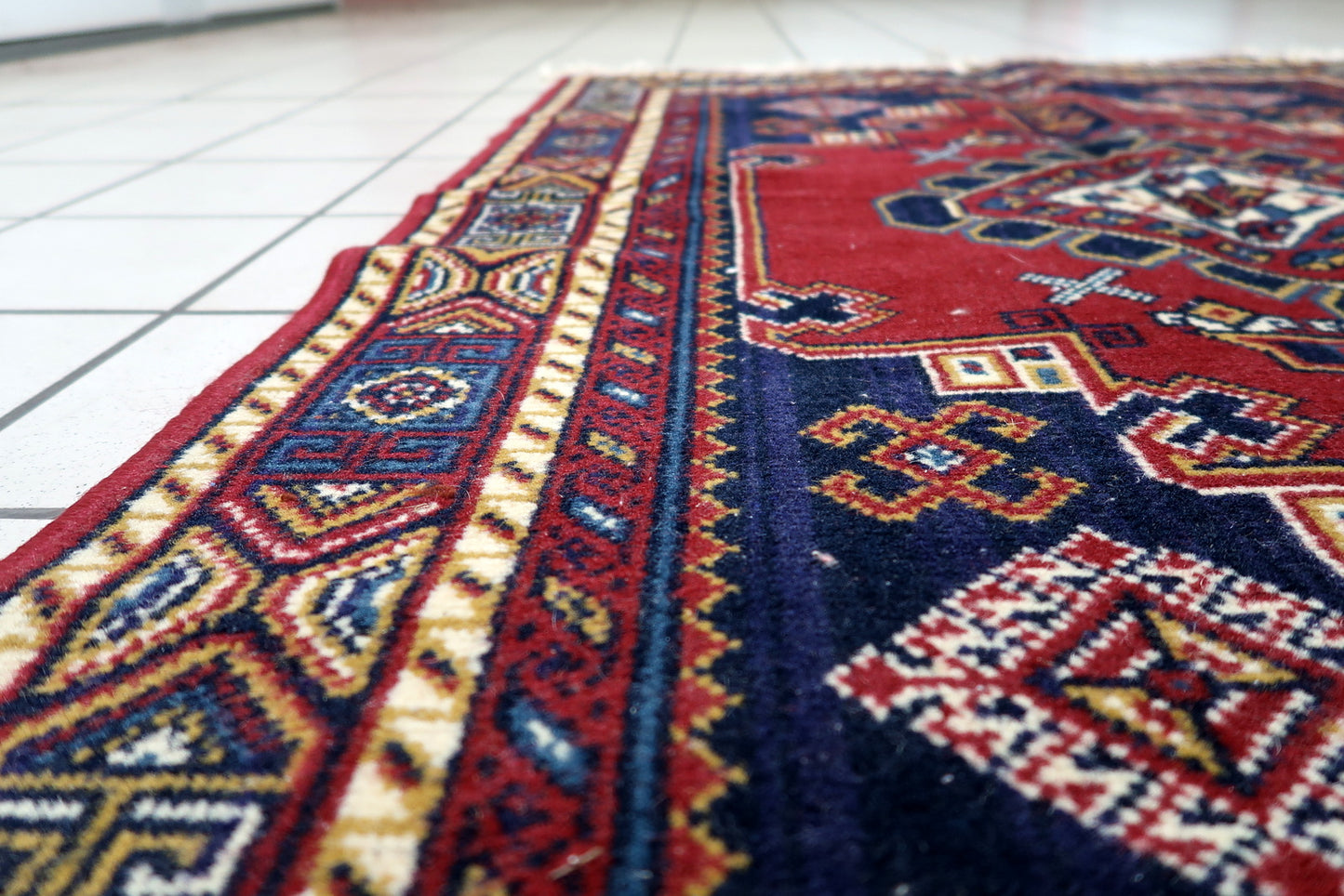 View of fringed ends adding classic finishing touch to a Persian-style floor covering with tribal aesthetics