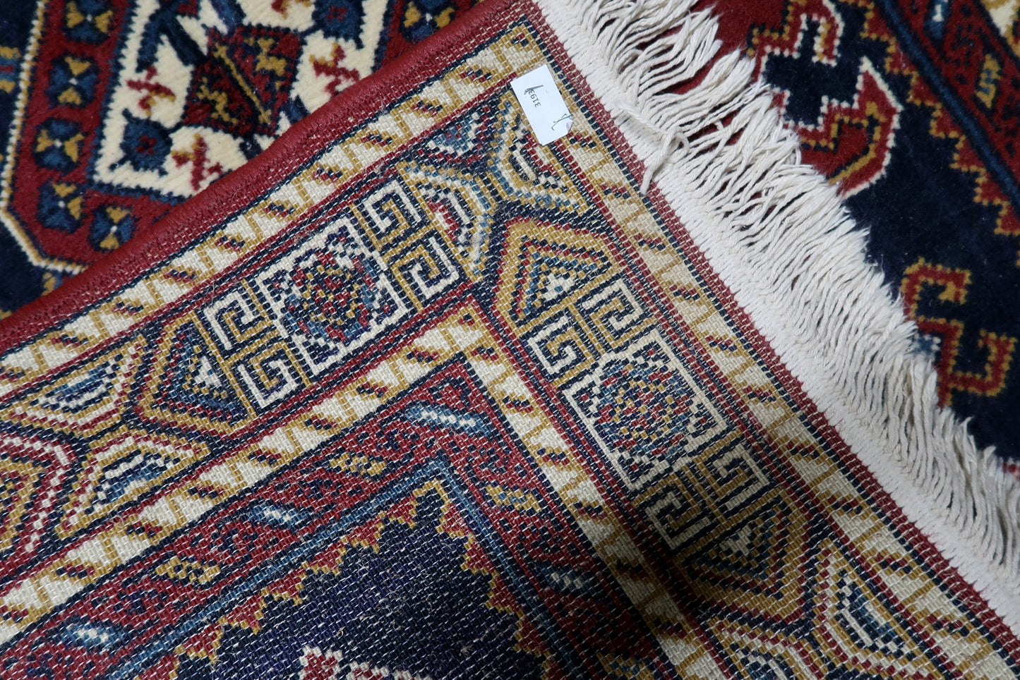 Red, navy, white, yellow and black vintage European rug with central diamond medallion and angular geometric motifs