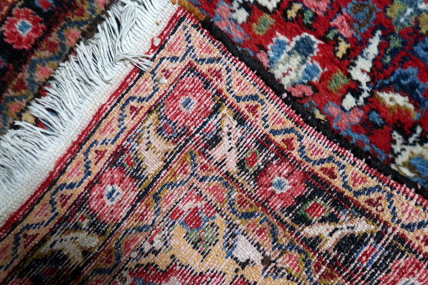 Warm red field with dark blue, ivory and accent tones on a distressed Persian Hamadan runner with authentic character