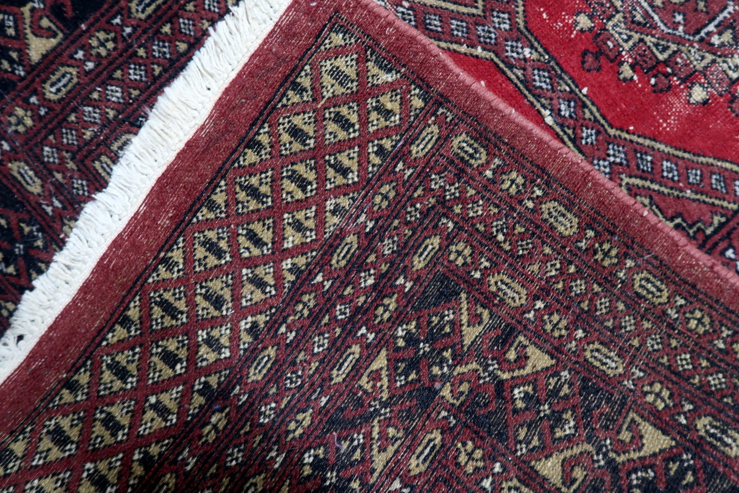 Wool pile texture of a distressed 1930s rug with naturally aged surface and areas of low pile