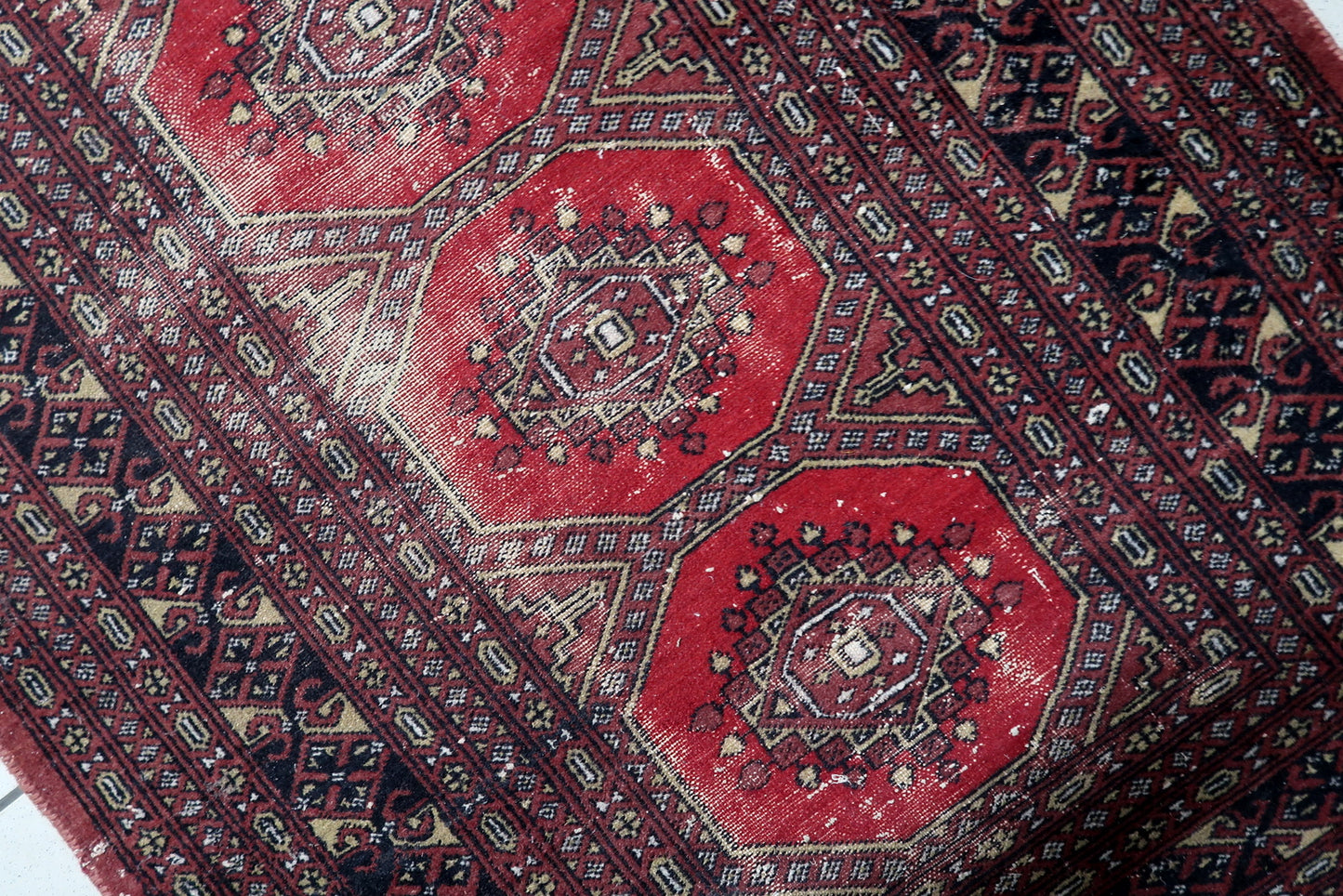Antique Uzbek Bukhara rug from the 1930s with four bold octagonal guls on a warm red field, distressed wool, 3 x 5.3 feet