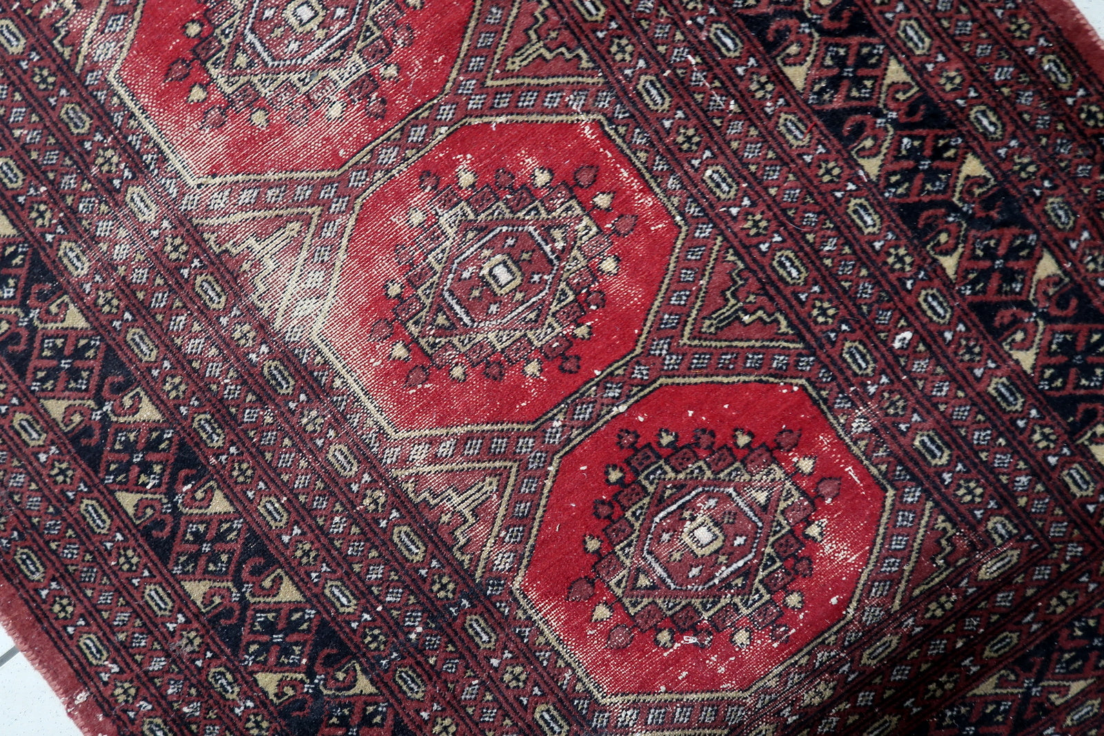 Antique Uzbek Bukhara rug from the 1930s with four bold octagonal guls on a warm red field, distressed wool, 3 x 5.3 feet