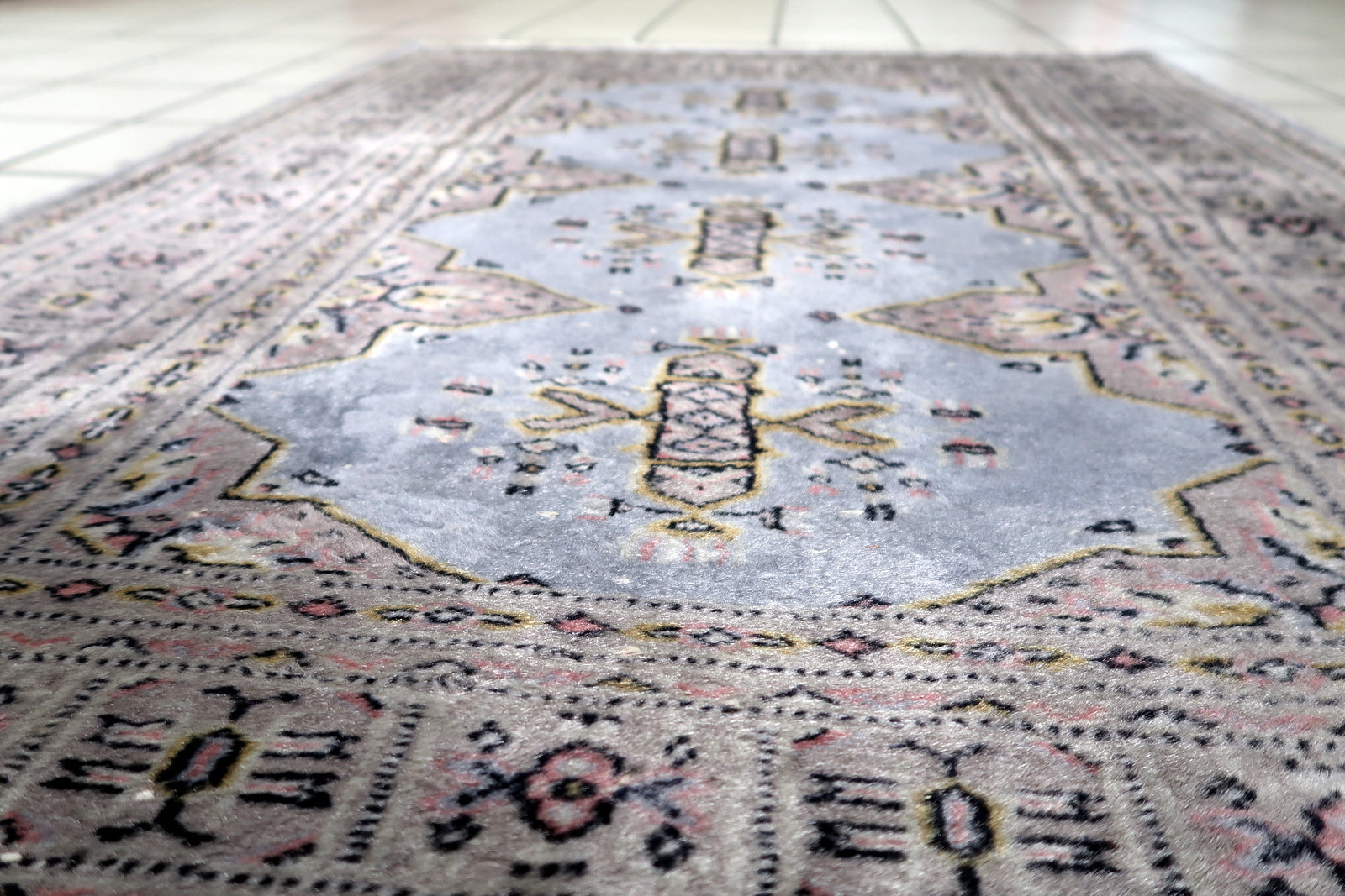 View of the compact size of a vintage Bukhara piece ideal for entryways or bedside placement