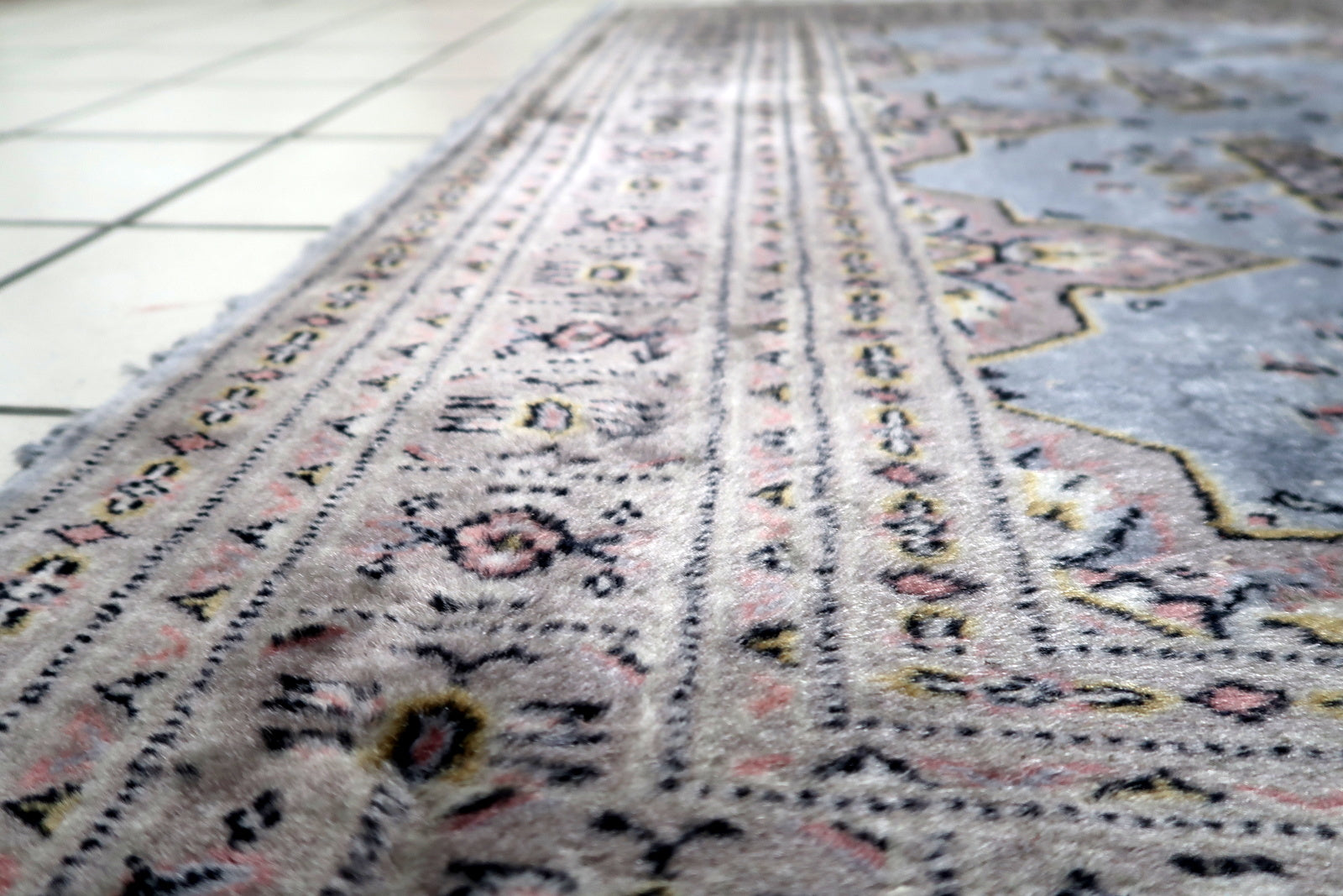 Muted red field with blue, ivory and dark accents on a vintage Uzbek Bukhara rug with refined tribal aesthetic