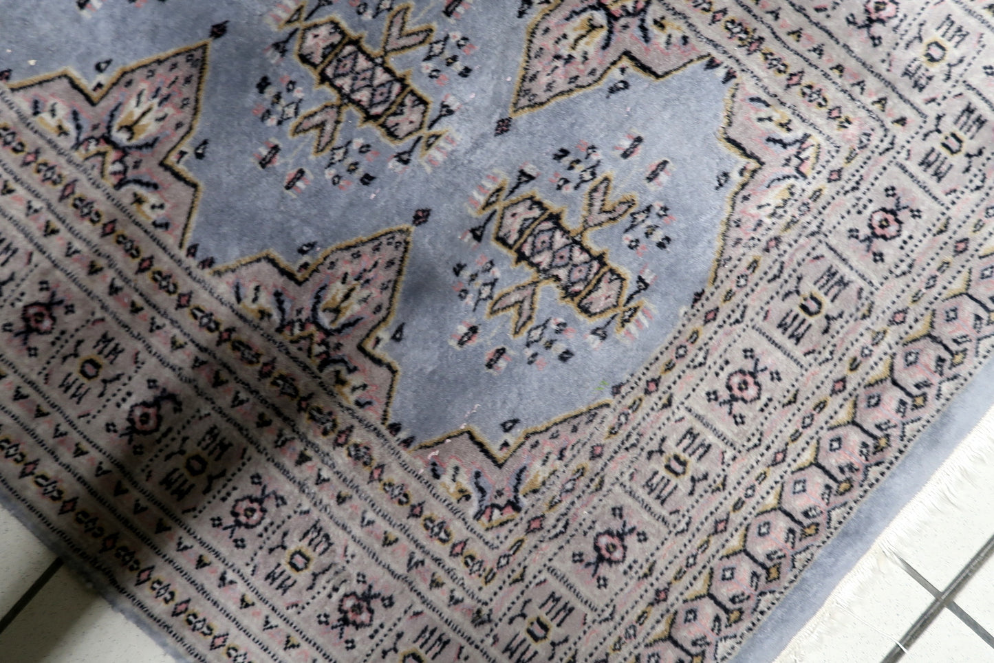 Vintage Uzbek Bukhara rug from the 1950s with repeating guls and stylized motifs in muted reds blues and ivory, 3.1 x 4.8 feet