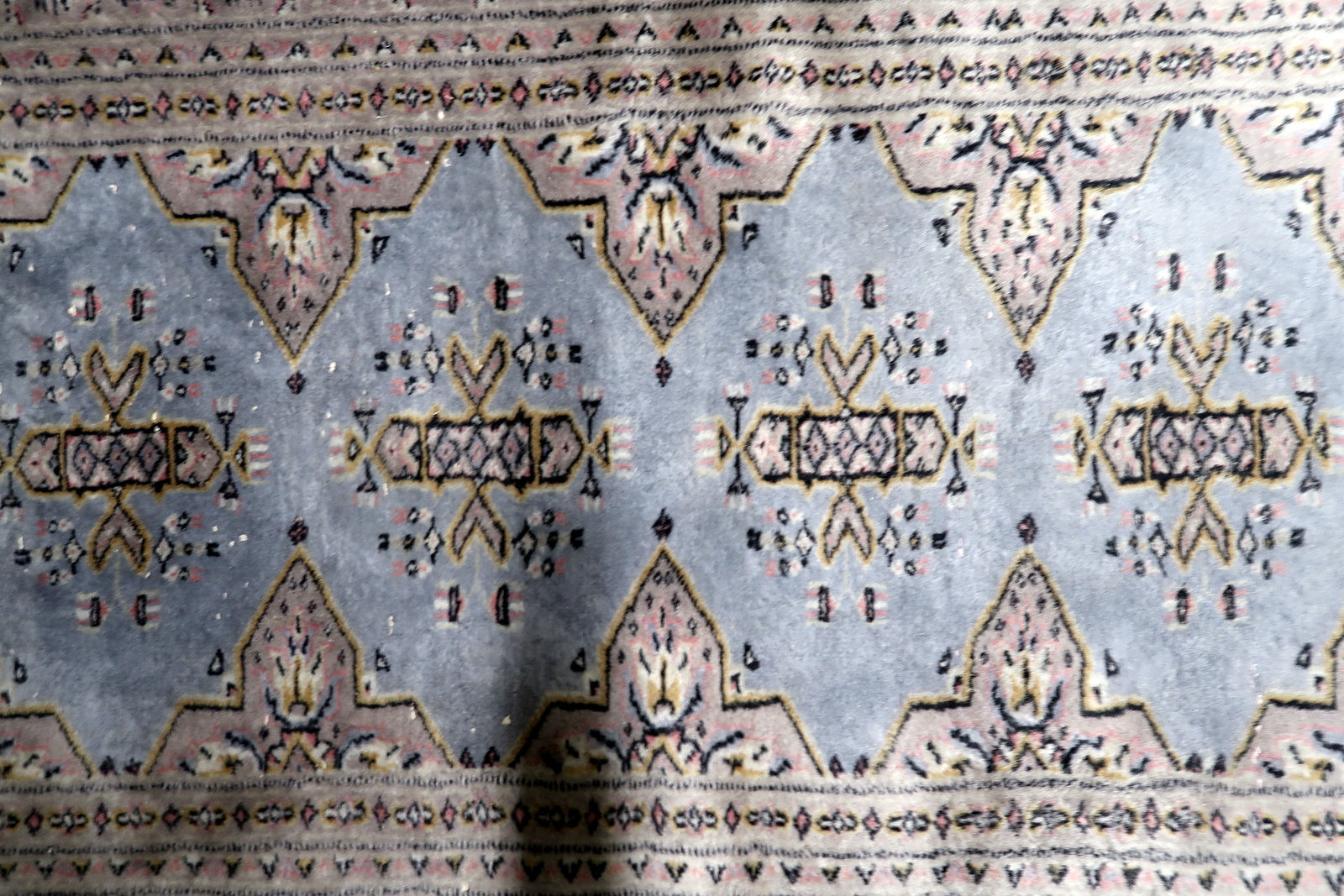 Close-up of traditional Bukhara gul motif with geometric borders and soft harmonious palette on hand-knotted wool