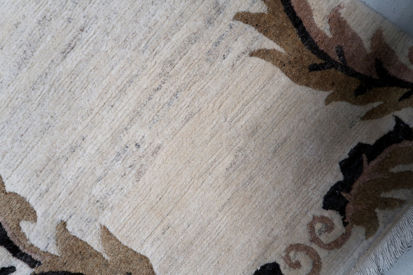 Neutral-toned vintage rug with stylized brown and black border designs, perfect for adding subtle pattern to a modern interior.


