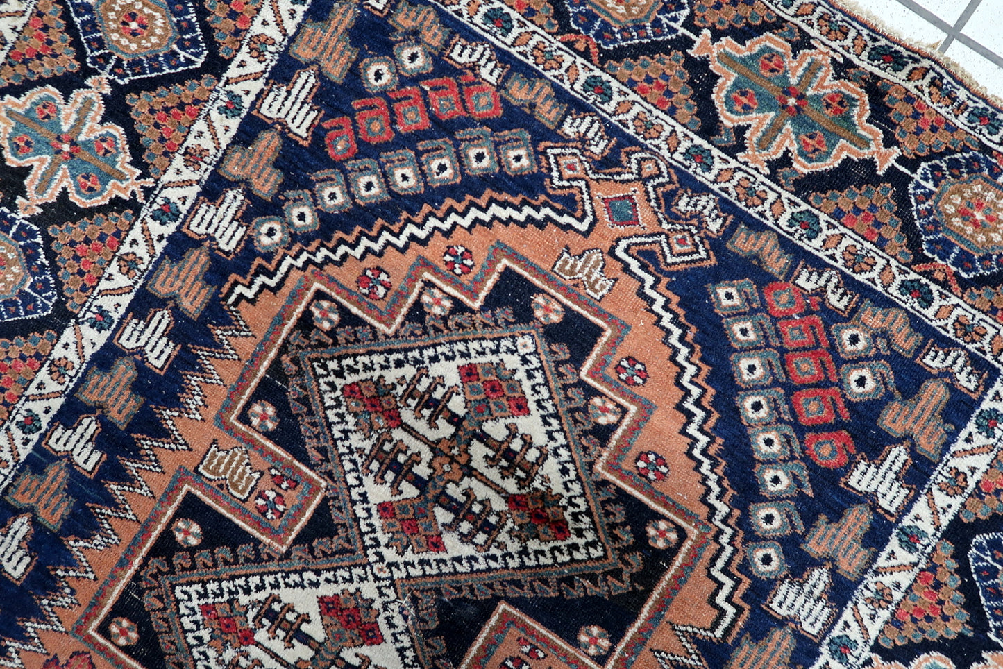 Early 20th-century Persian Afshar rug, 3.8 x 4.6 feet, with intricate geometric and floral borders in deep navy, rust, red, and green tones.

