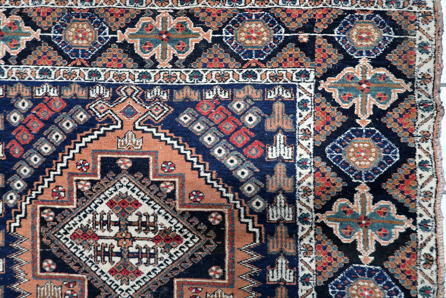 Full view of a handmade 1920s Afshar rug showing its bold composition of three striking diamond medallions surrounded by patterned borders.

