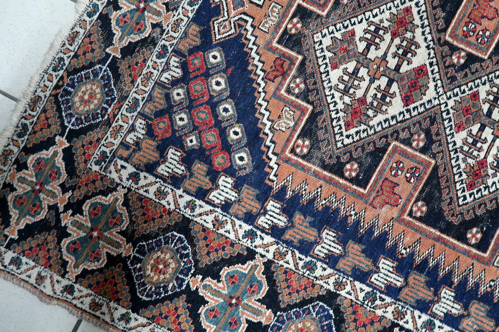 Antique Afshar rug with three prominent diamond medallions arranged vertically on a richly patterned field in navy, rust, and ivory.

