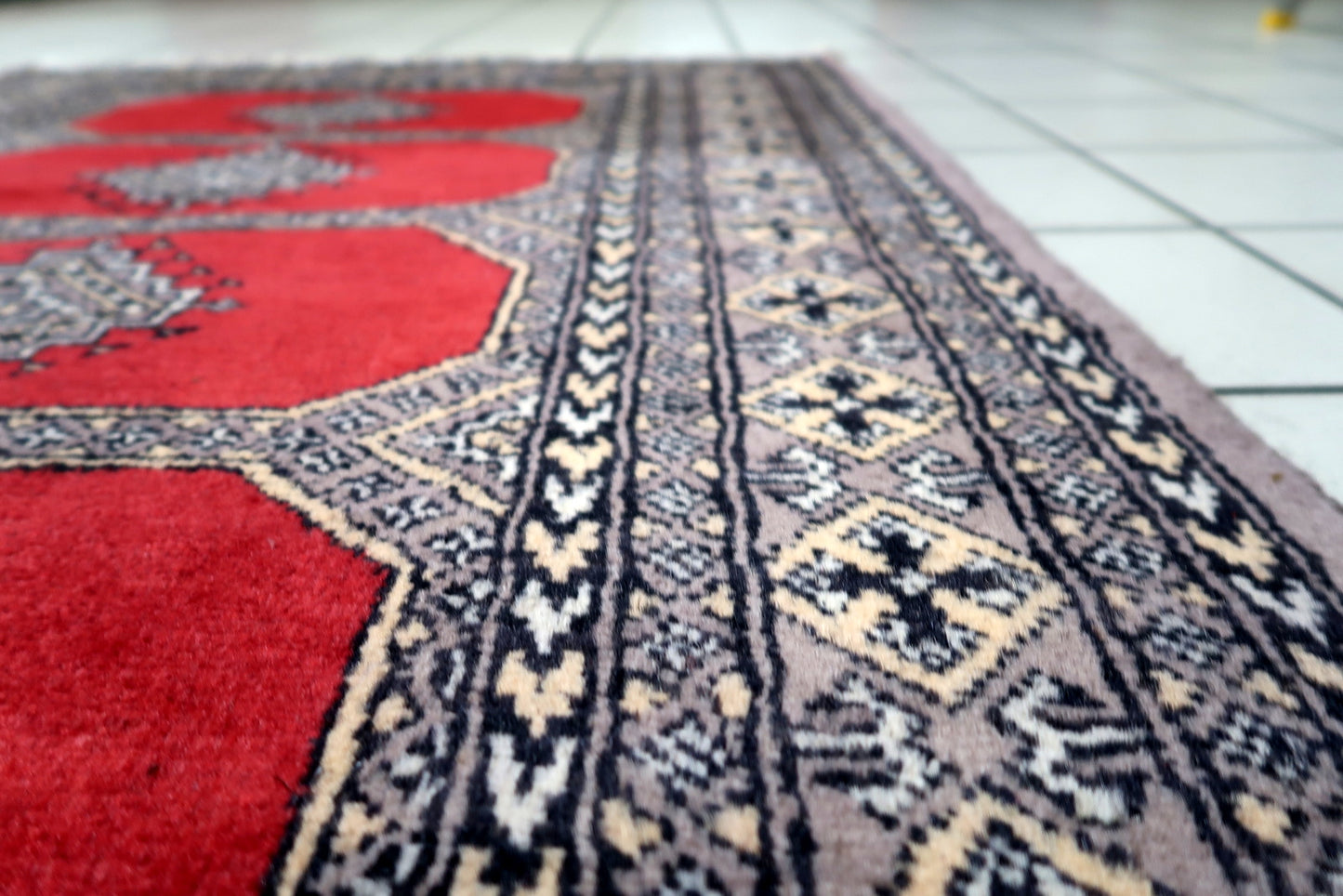 Vintage tribal rug featuring a striking all-over pattern with repeat octagonal motifs in red, black, and ivory.

