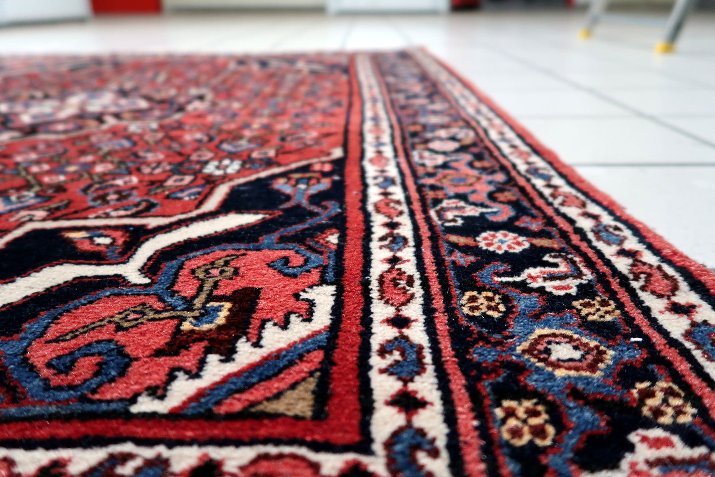 Corner detail showing intricate layering of patterns on vintage Persian village rug

