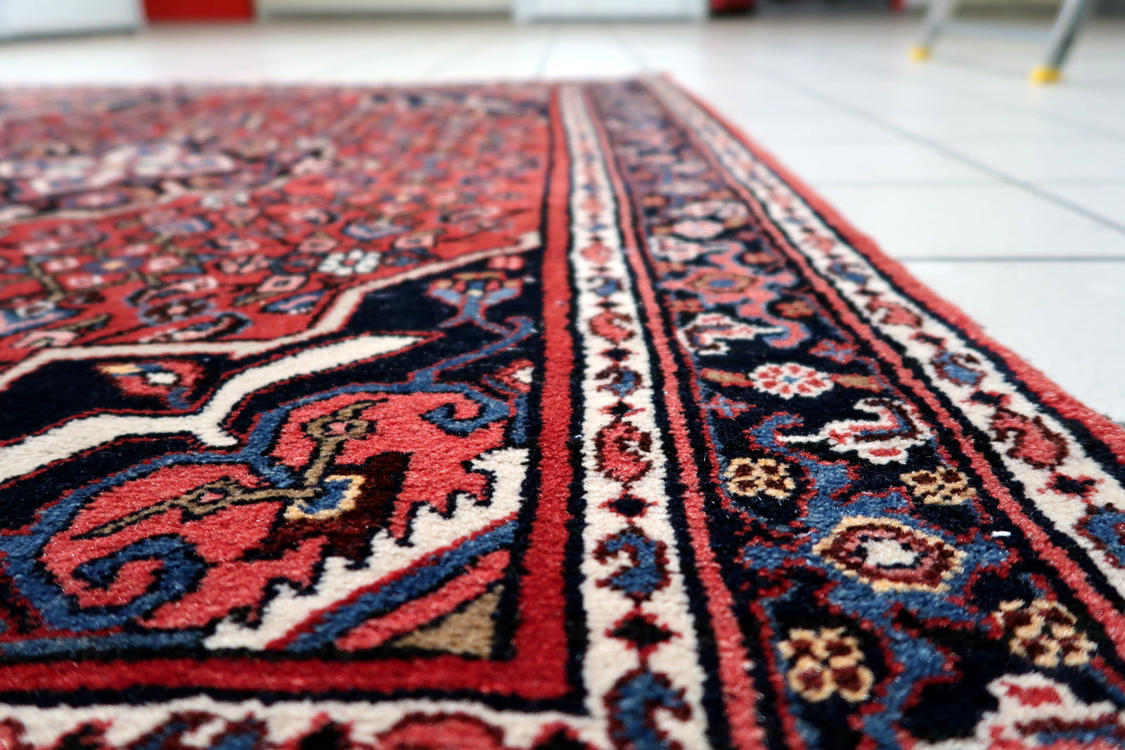 Corner detail showing intricate layering of patterns on vintage Persian village rug
