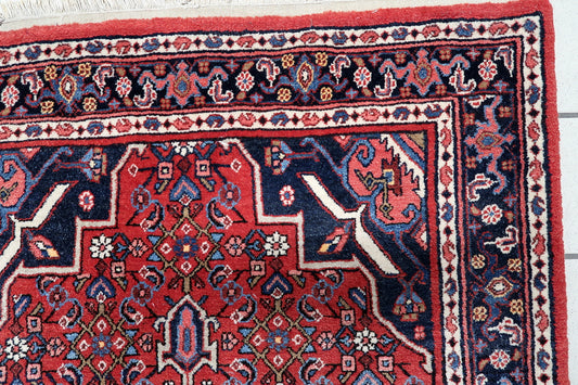 Mid-century Persian Hamadan carpet with vibrant red field and navy blue motifs on floor
