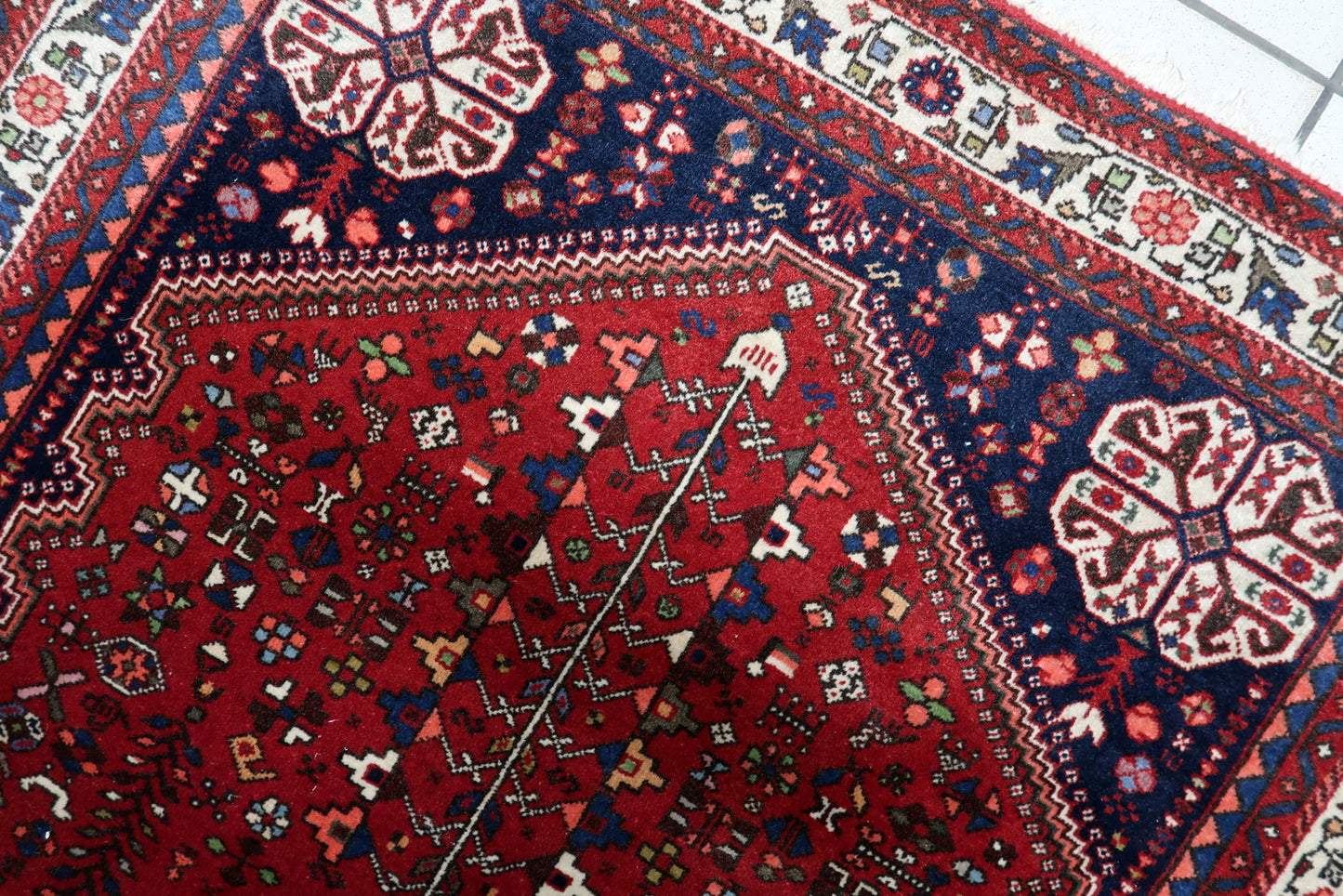 Close-up of 1920s Qashqai rug displaying intricate geometric and floral tribal motifs

