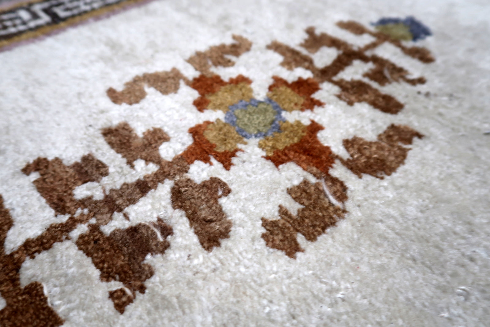 Close-up of golden-yellow pagoda-style medallion with soft moss green and muted blue accents
