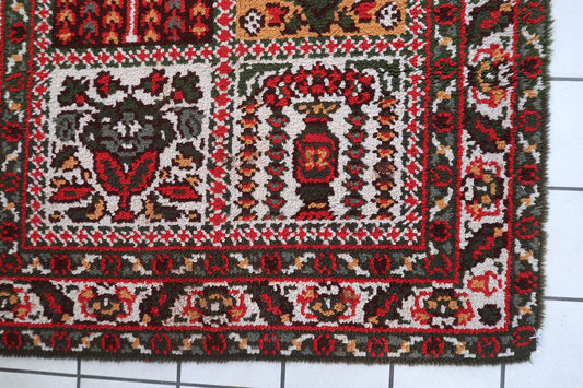 Mid-century French provincial rug with delicate pastel palette of soft pink sage green and pale blue on floor

