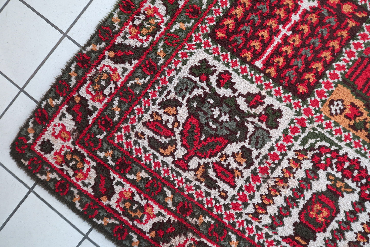 Close-up of classic Savonnerie rug showcasing scrolling borders and architectural balance of French weaving

