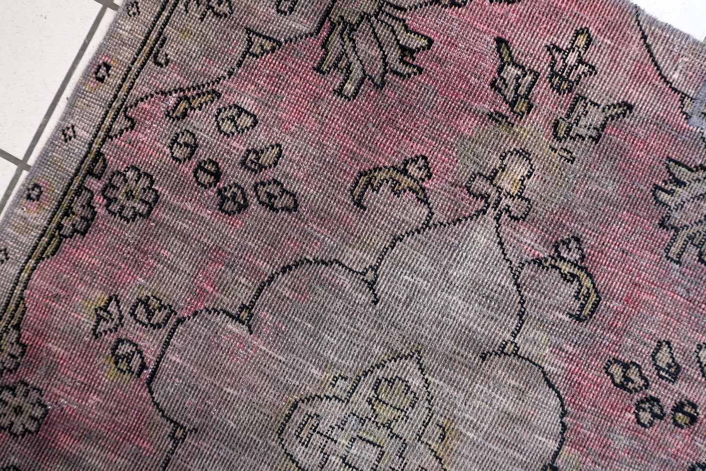 Hand-knotted Anatolian rug circa 1940s with sun-faded terracotta deep indigo and weathered charcoal colors

