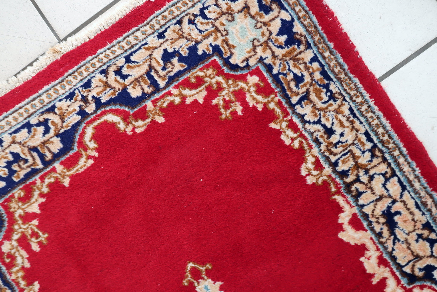 Close-up of intricate Kerman rug showcasing blooming vines palmettes and delicate botanical details

