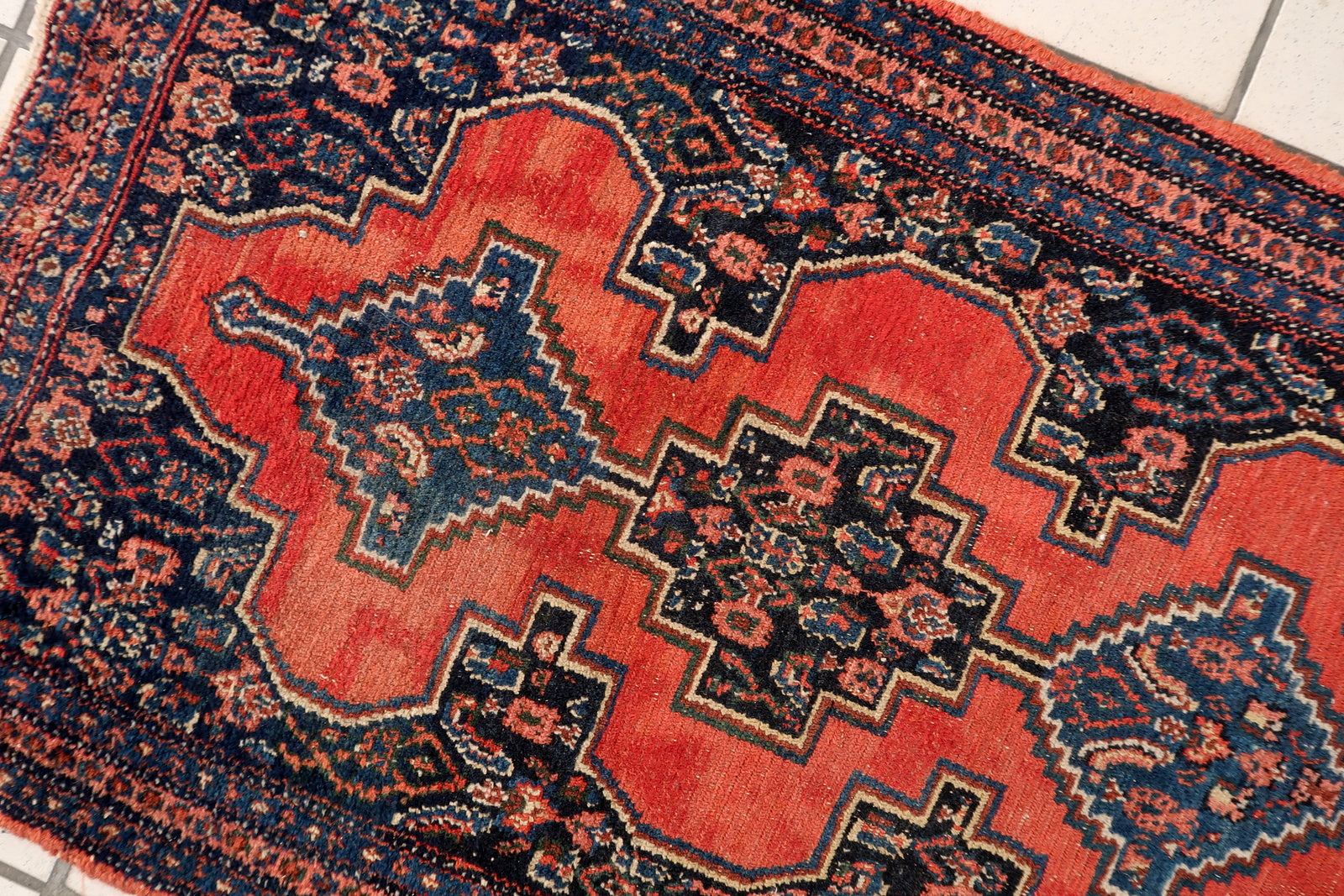Persian Senneh wool rug close-up, showing detailed knotting and fine texture