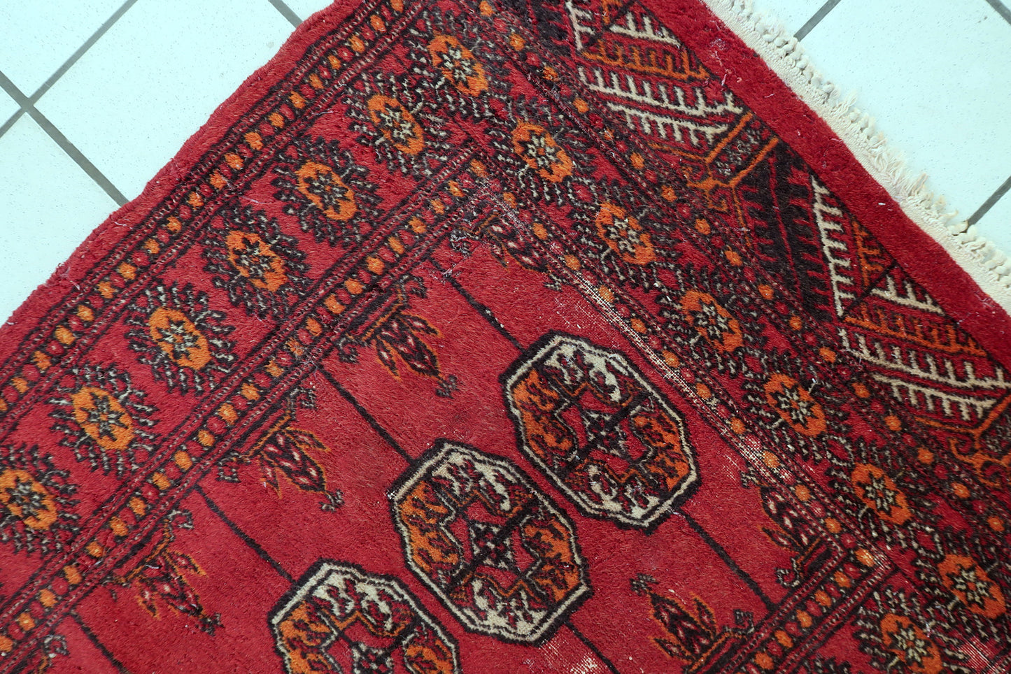 Vintage Bukhara rug close-up, showing hand-knotted wool texture and pattern