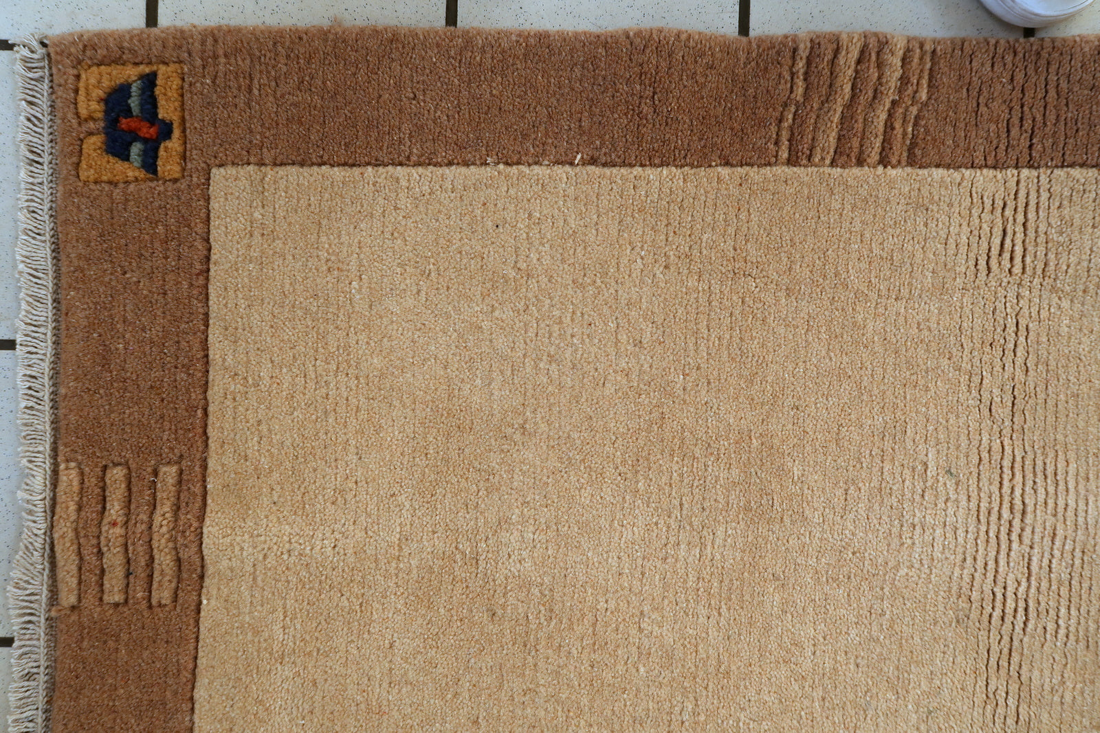 Vintage Tibetan wool rug detail, minimalist composition with subtle motifs