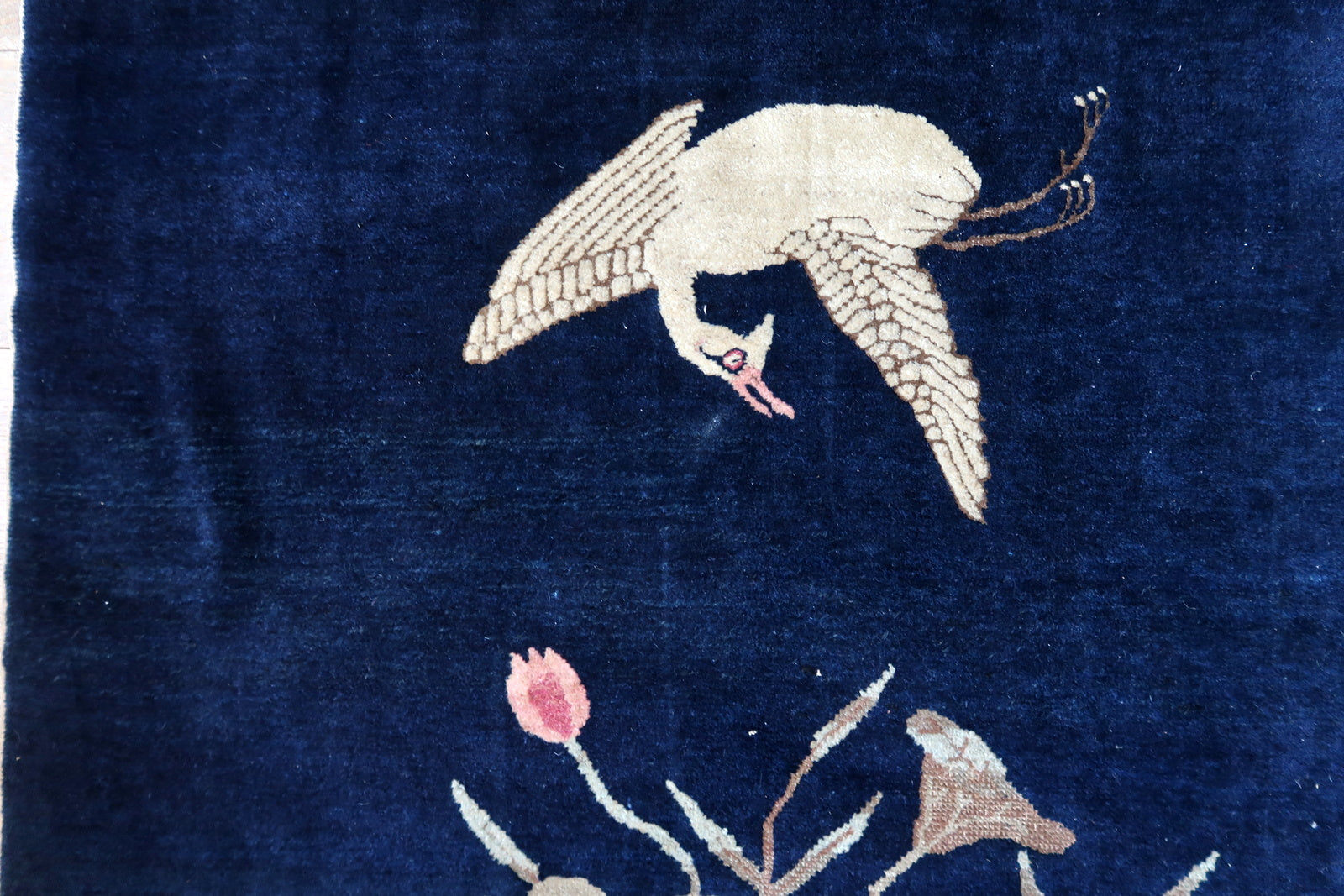 Antique Chinese rug close-up, showing crane motif and hand-knotted texture