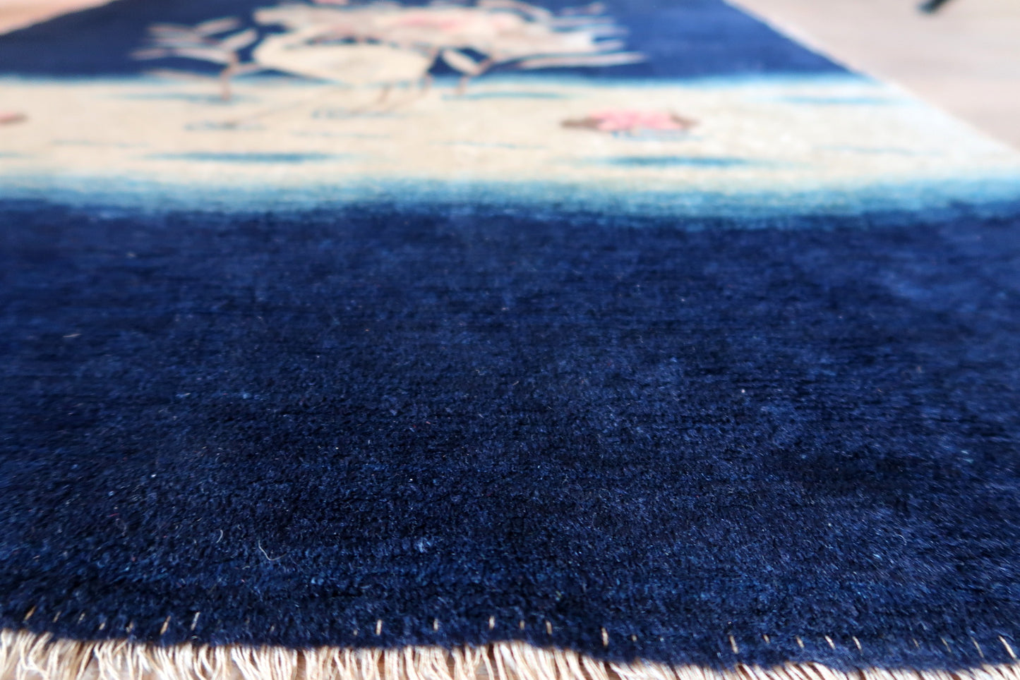 Peking rug texture detail, dense wool pile with soft muted palette