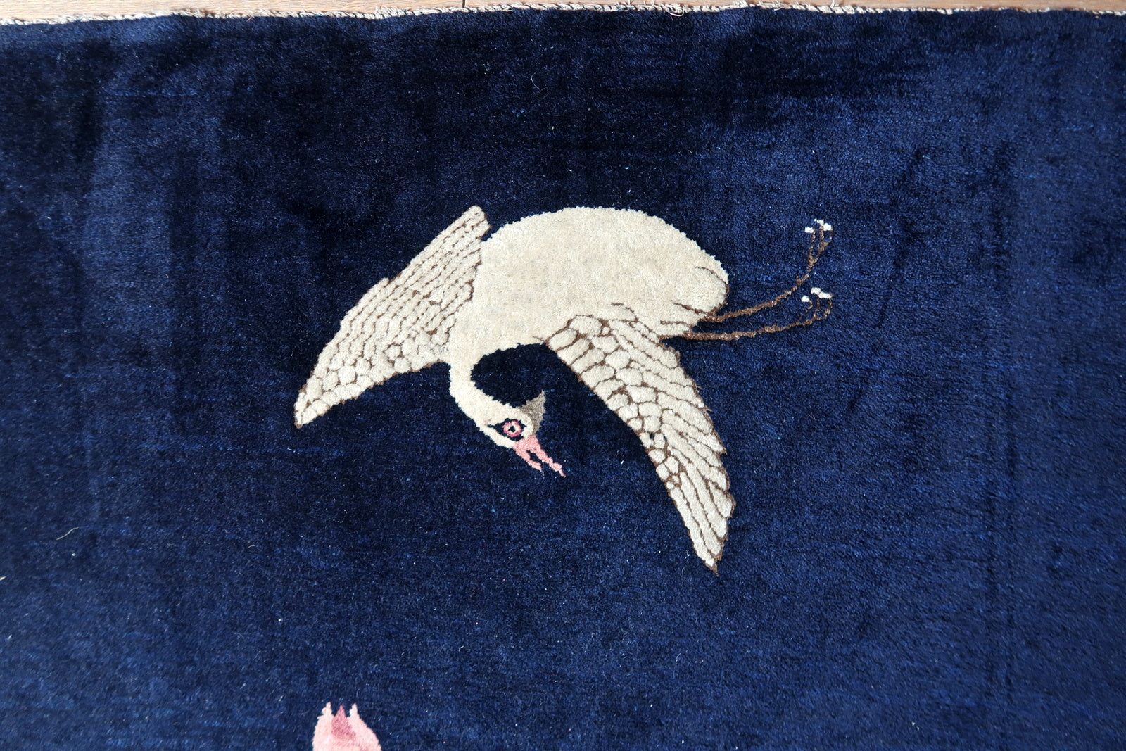Antique Chinese rug close-up, showing crane motif and hand-knotted texture