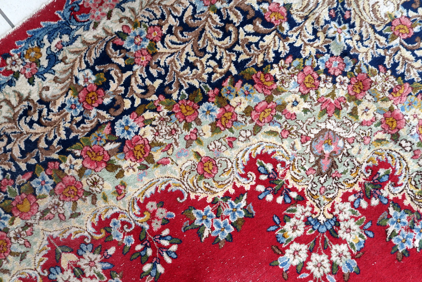 Persian Kerman rug detail, floral vines and arabesque patterns in rich tones