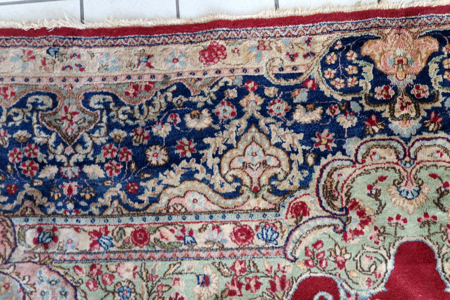 Antique Kerman rug close-up, showing dense wool pile and fine knotting