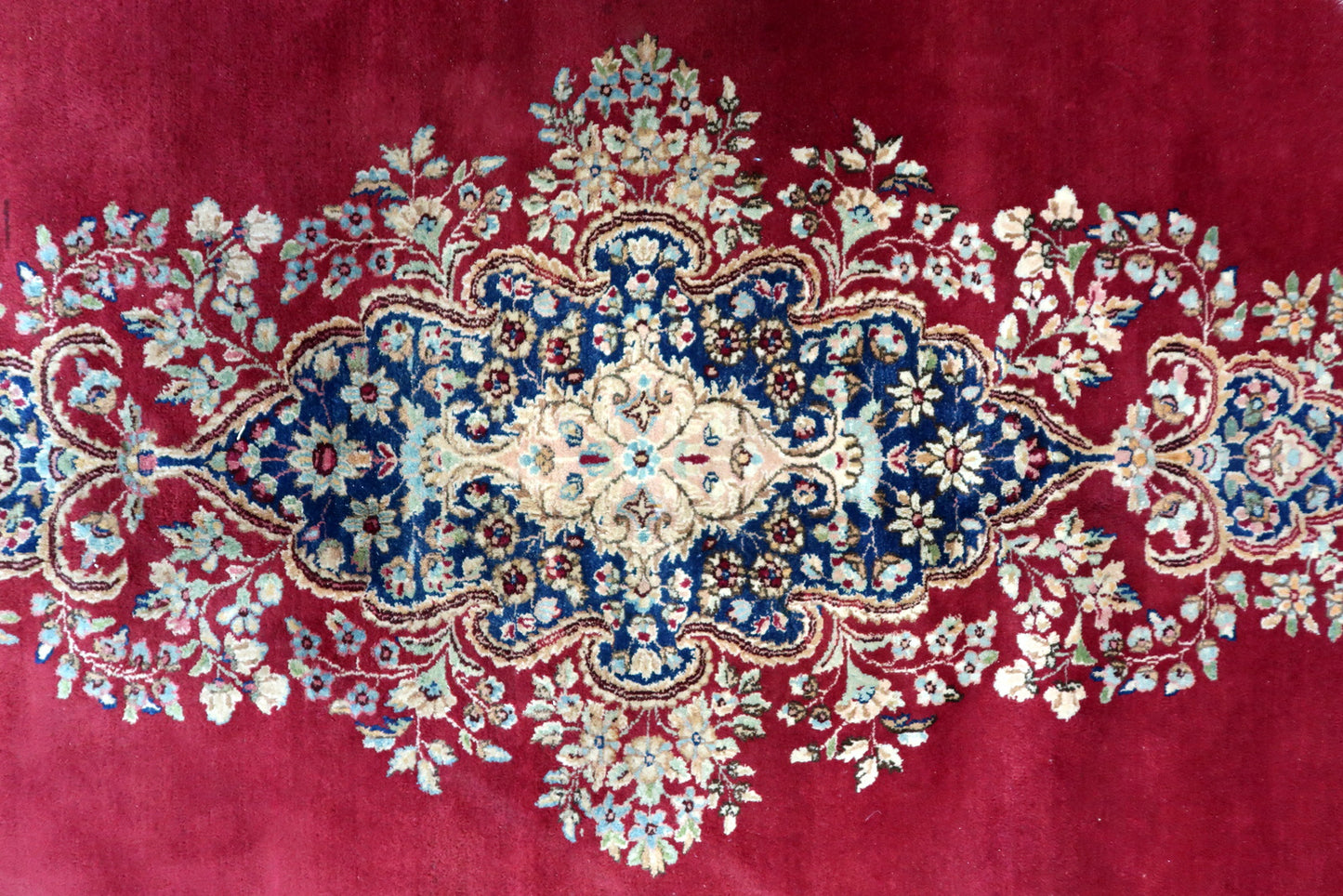 Hand-knotted Kerman rug, red field with detailed floral medallion design