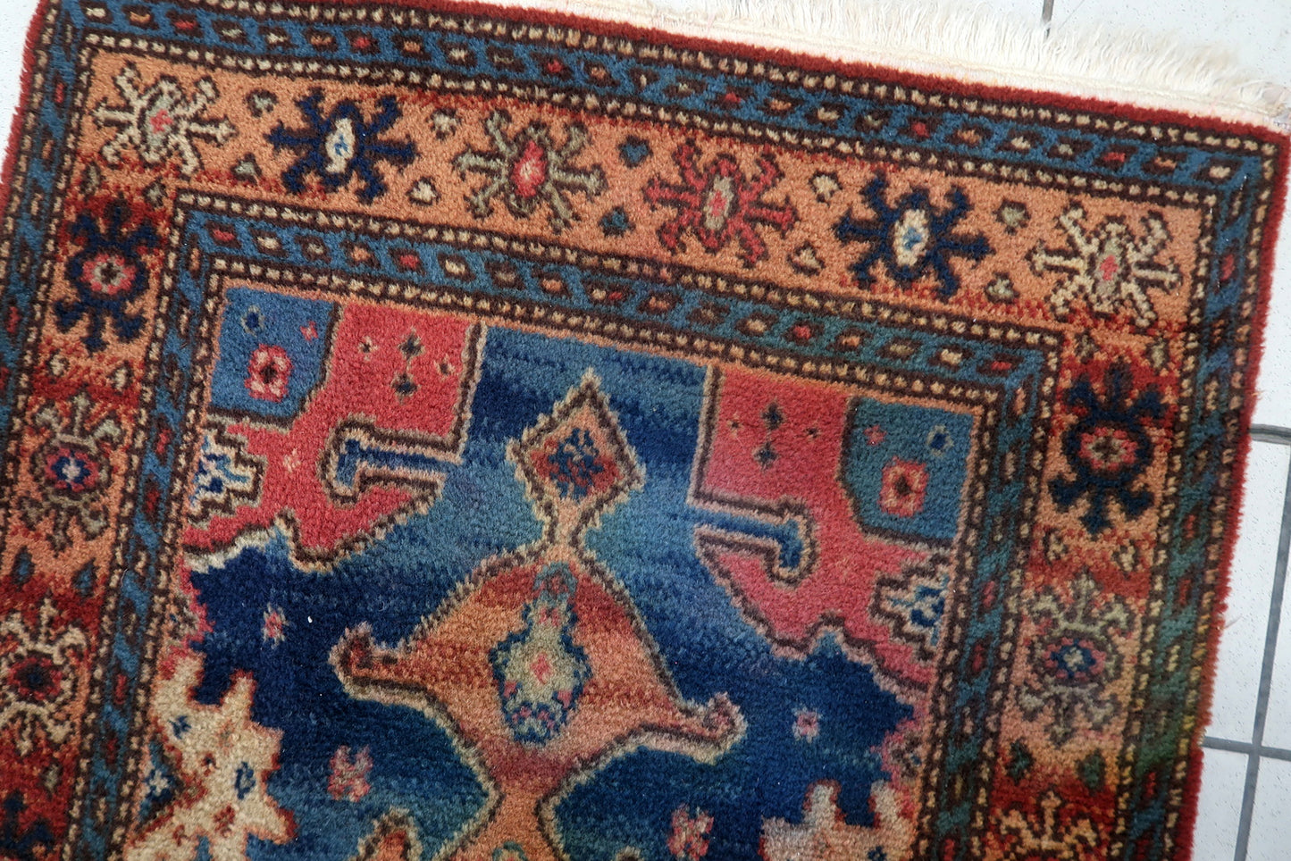 Vintage German rug corner detail, showcasing craftsmanship and aged patina